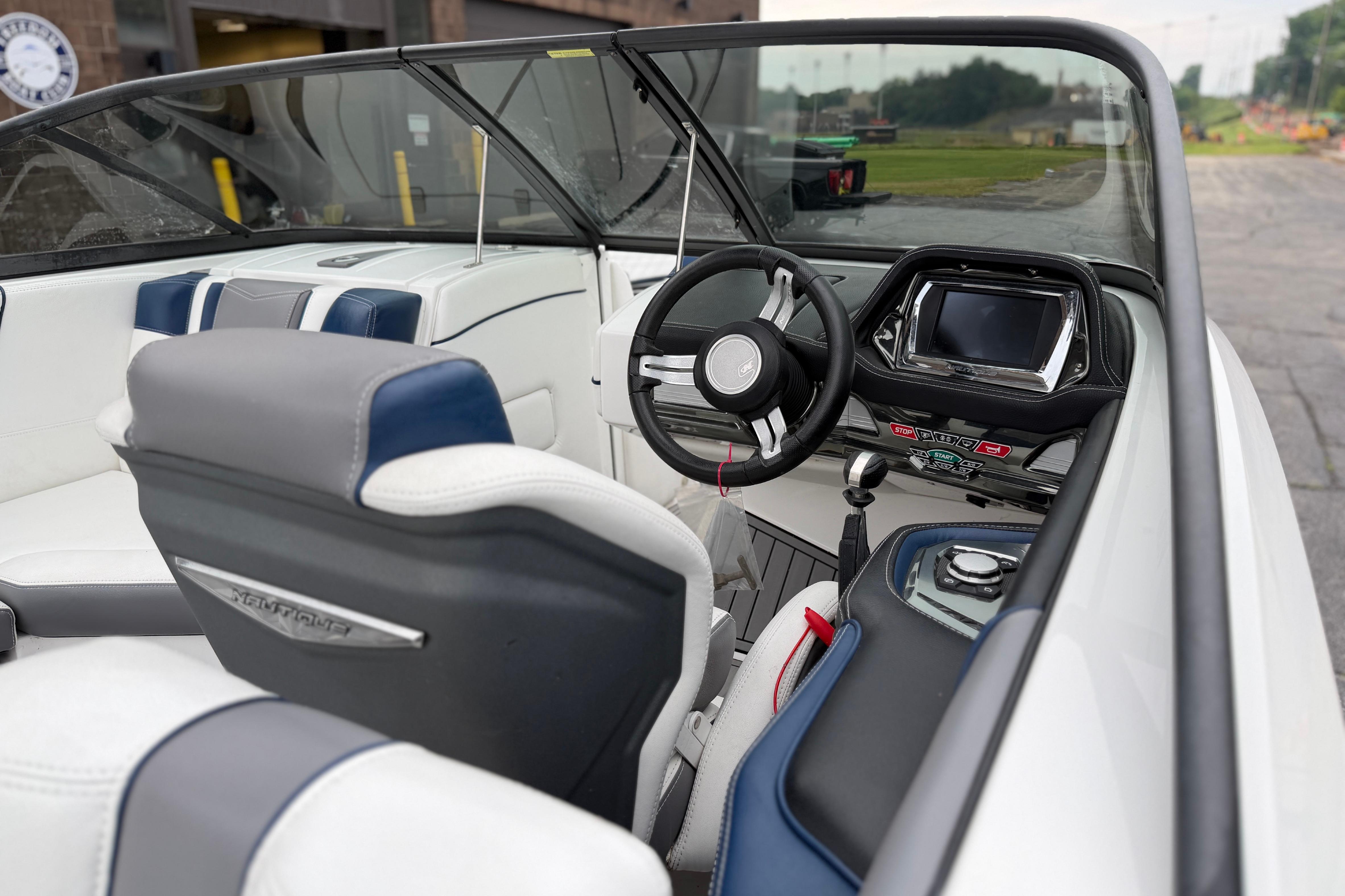 Interior of a 2016 Naitique G25 boat, featuring steering wheel and dashboard controls.