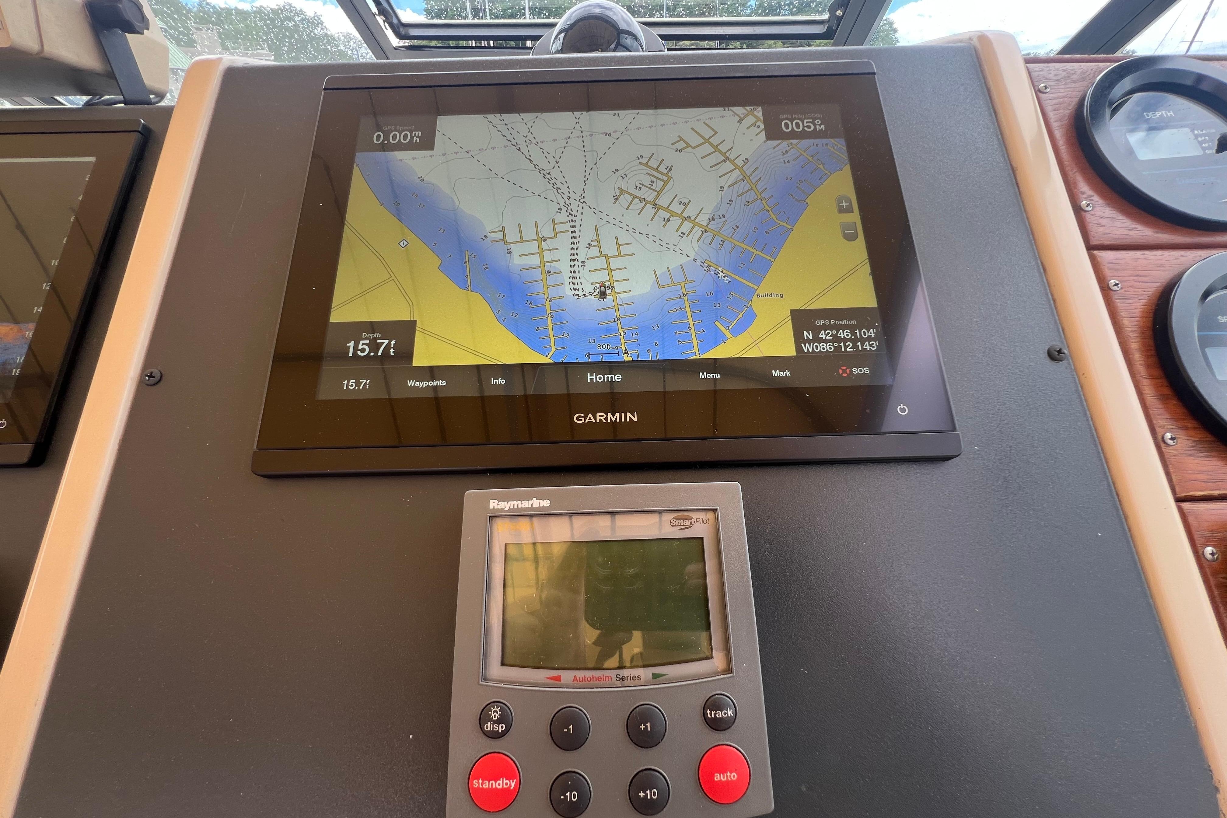 Garmin navigation display on 1985 Tiara 36 OPEN boat dashboard with Raymarine control panel.