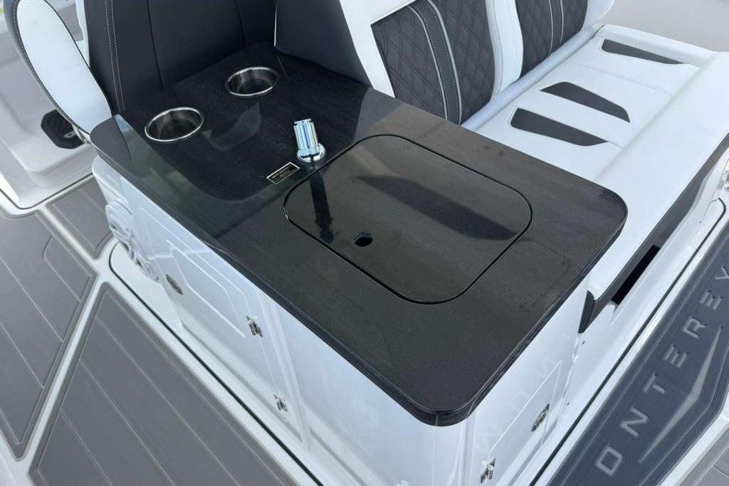 Luxury seating area on 2026 Monterey Elite 30 OB boat with cup holders and sleek design.
