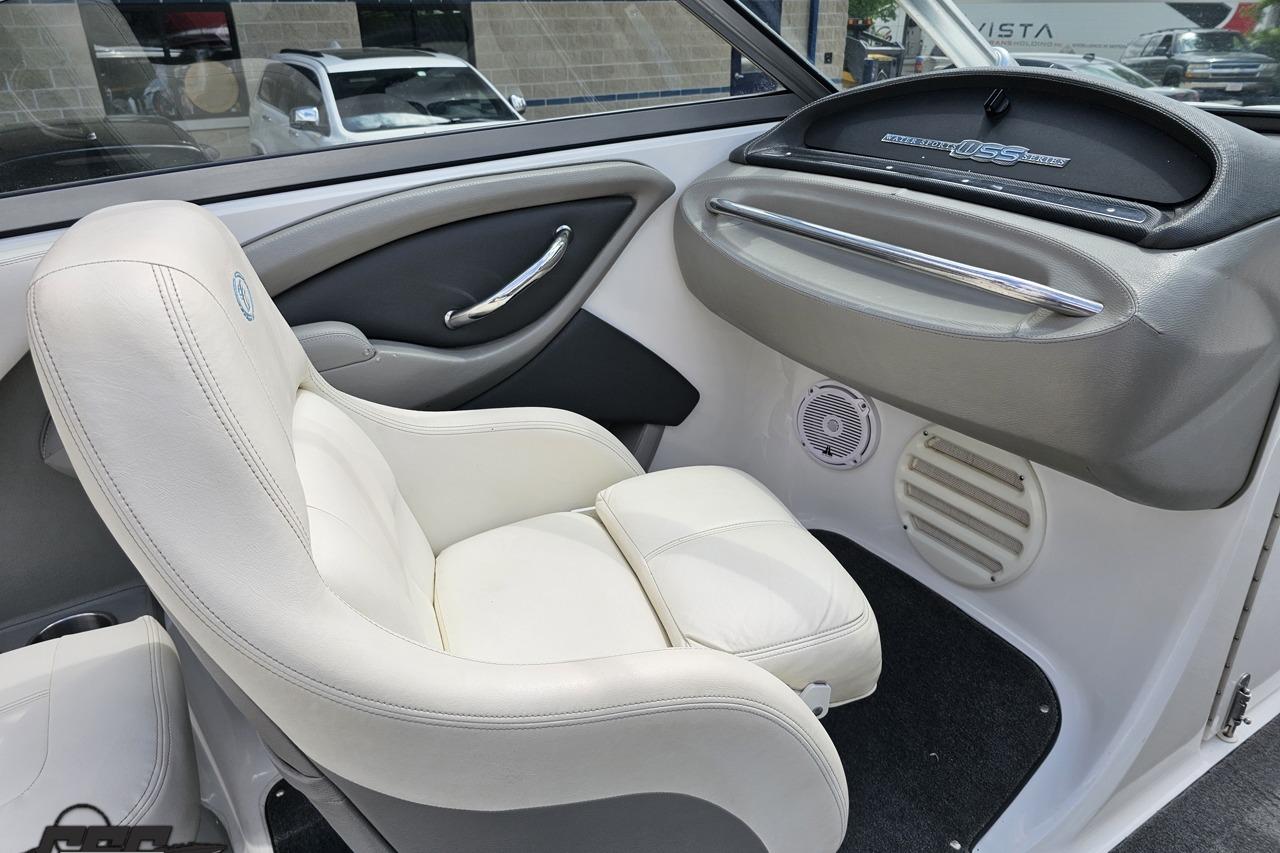 Interior of a 2010 Cobalt 232 WSS boat with white leather seating and sleek dashboard.