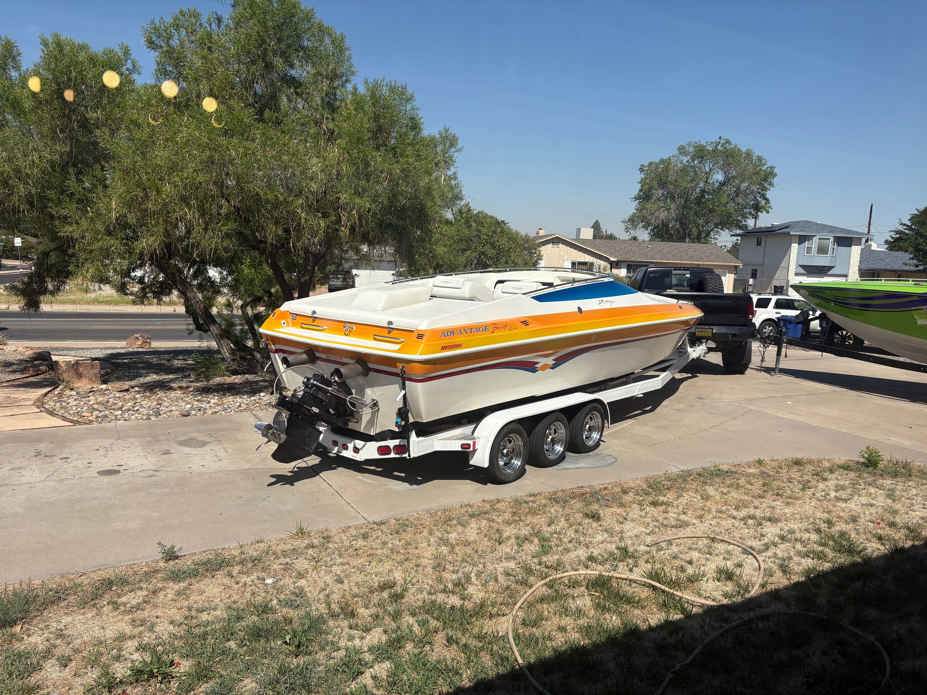 2001 Advantage 27 Victory on a trailer, featuring a yellow, orange, and blue stripe design.