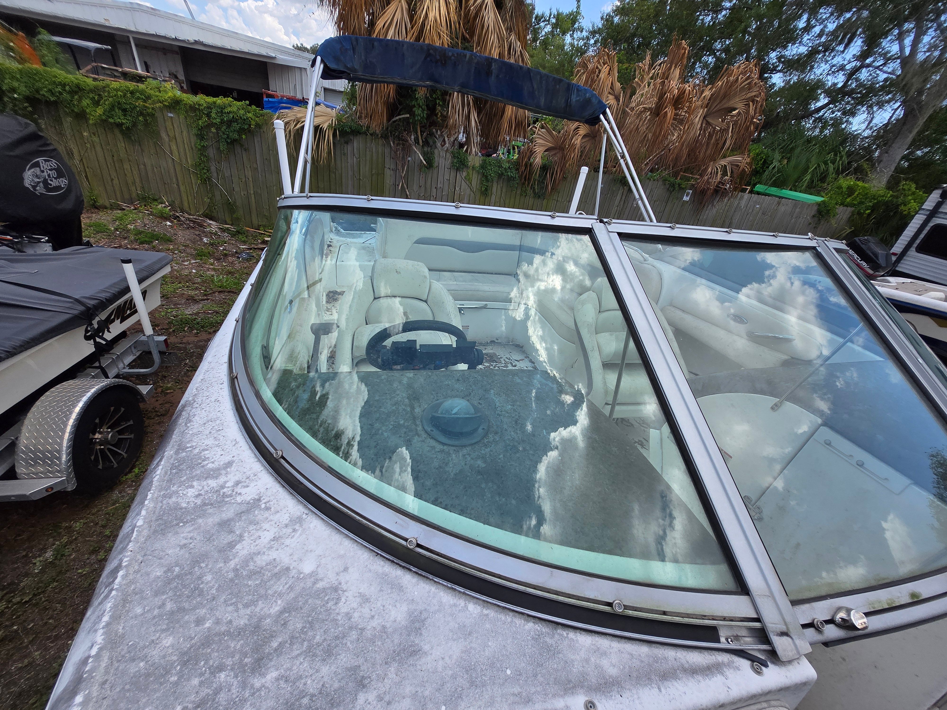 A 2006 Chaparral 220 SSi boat is on land. It features a windshield and white seating.