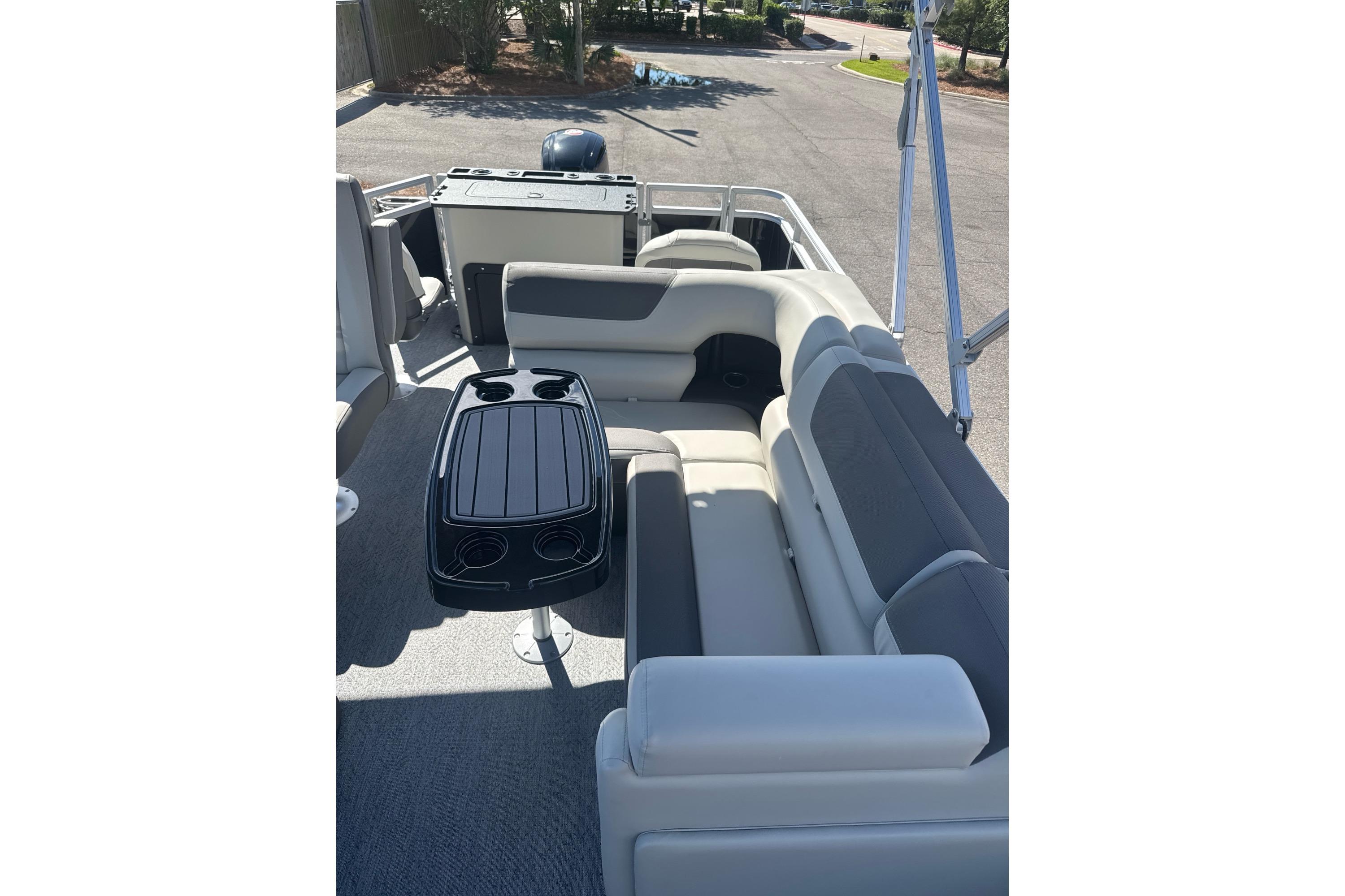 2026 Sun Tracker Fishin' Barge 20 DLX interior with seating and table, ideal for leisure.