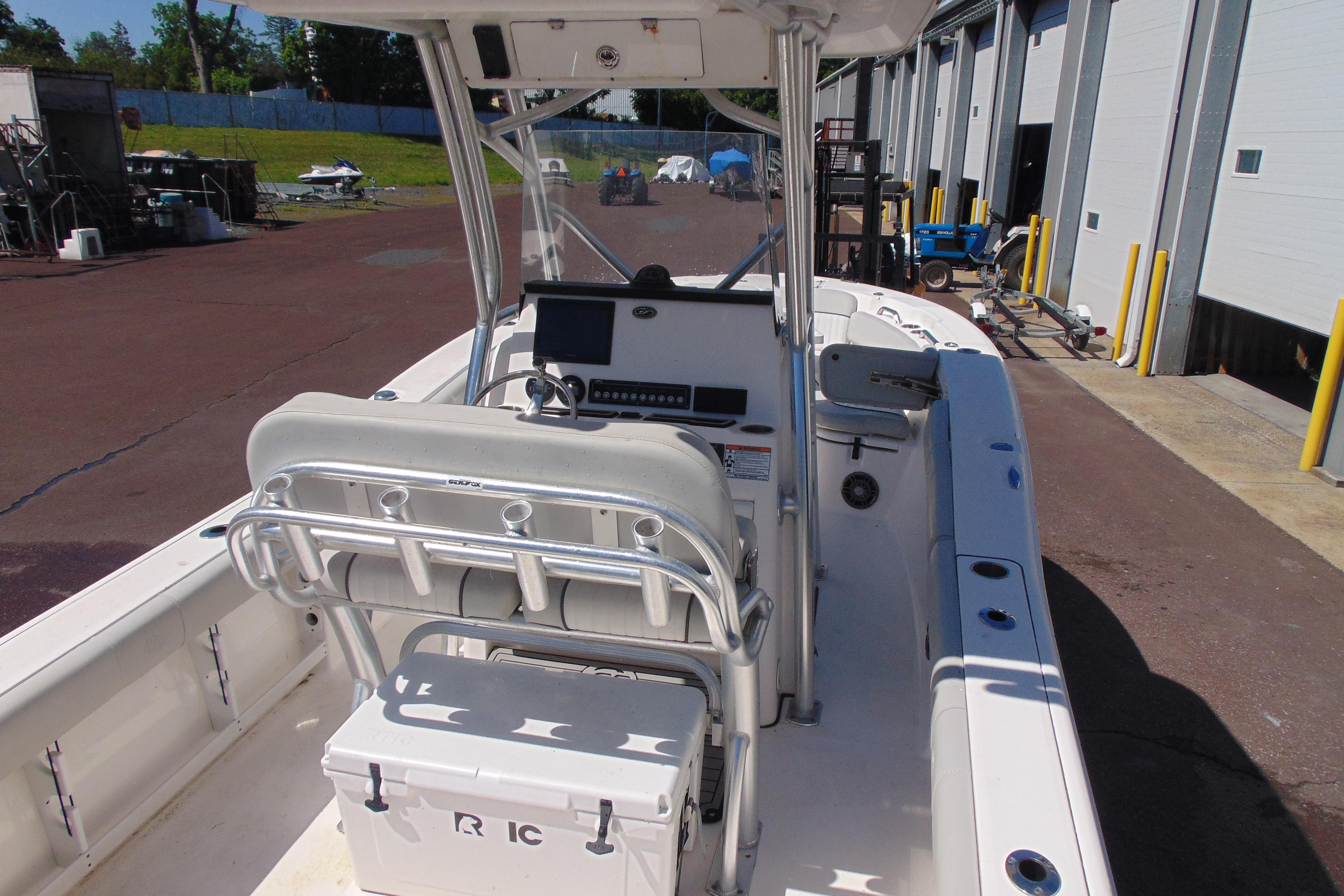 2022 Sea Fox 248 Commander boat interior with helm and seating, docked near industrial buildings.