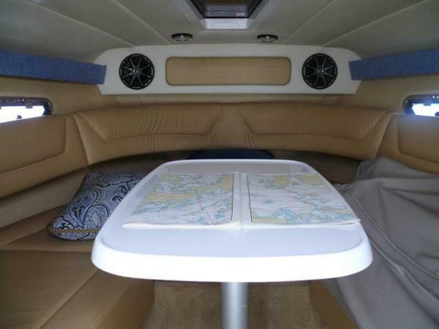 Interior of a 2012 Cobalt 273 boat with a table and seating area.