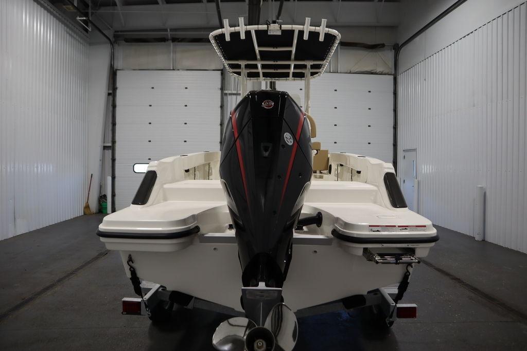 2026 Bayliner Trophy T20CC boat in a garage, rear view with outboard motor.