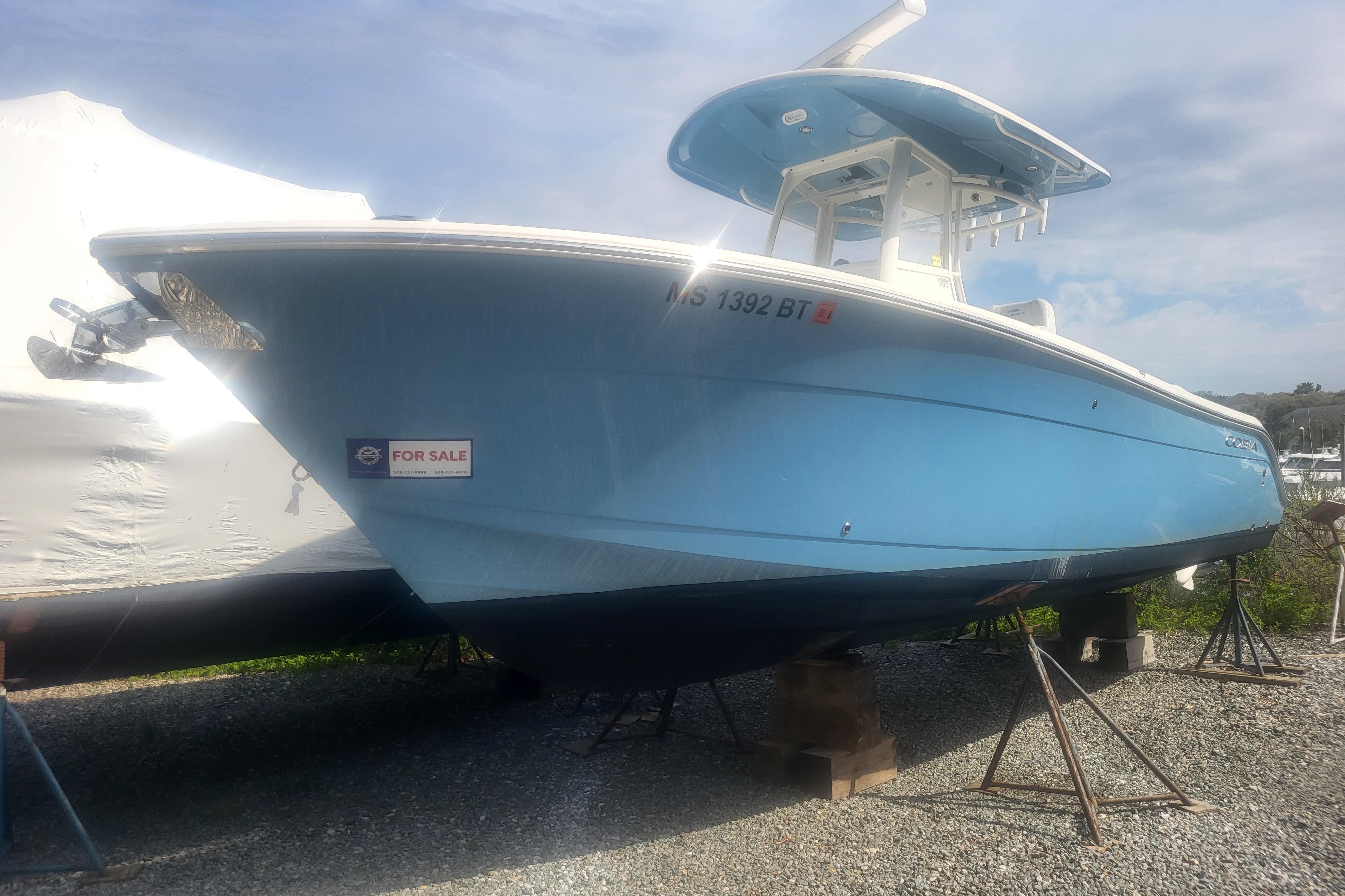 2022 Cobia 262 Center Console boat for sale, light blue hull, parked on stands.