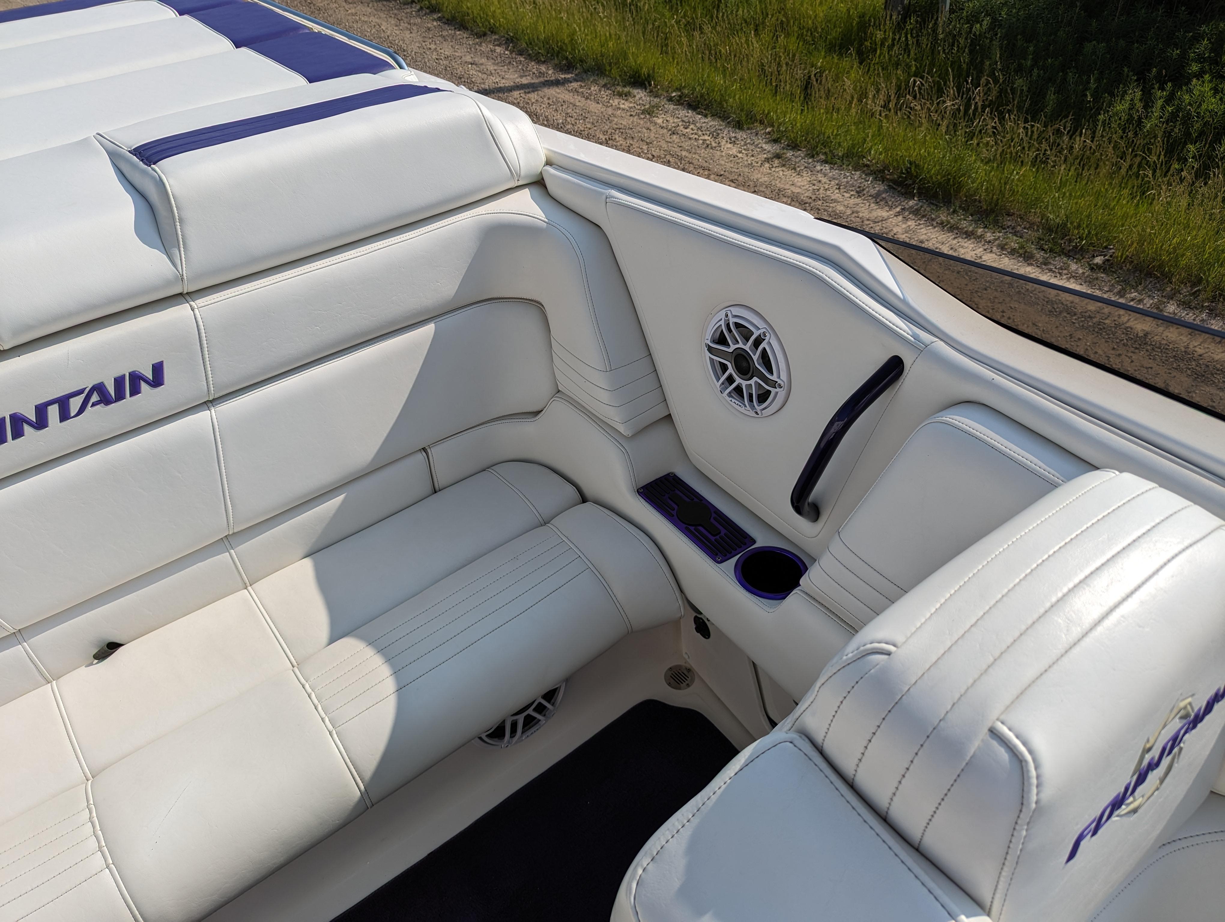 White leather seating on a 2006 Fountain 42 boat, featuring cup holders and speaker.