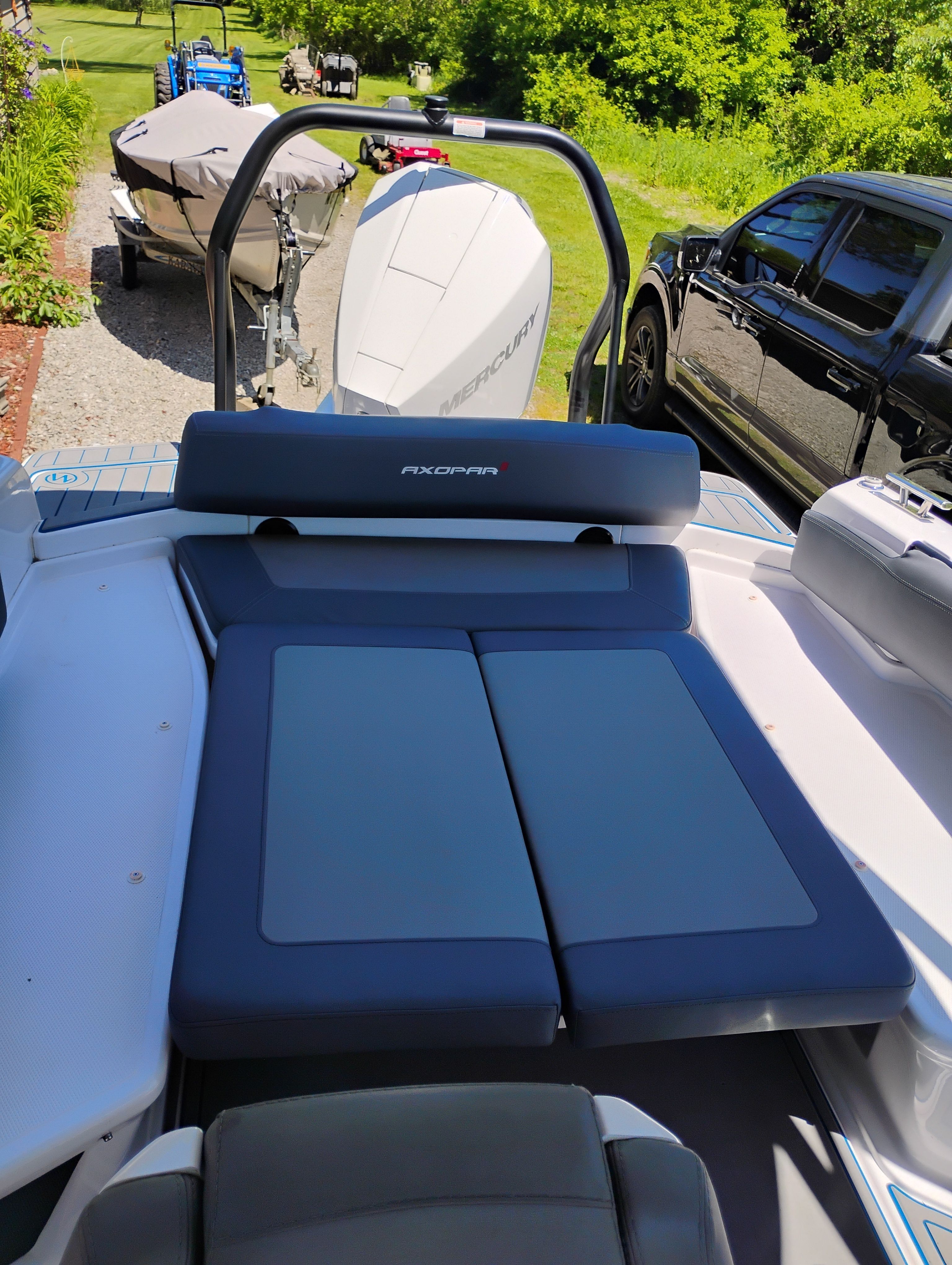 Axopar 22 T-Top 2022 with sunbed and engine outdoors.
