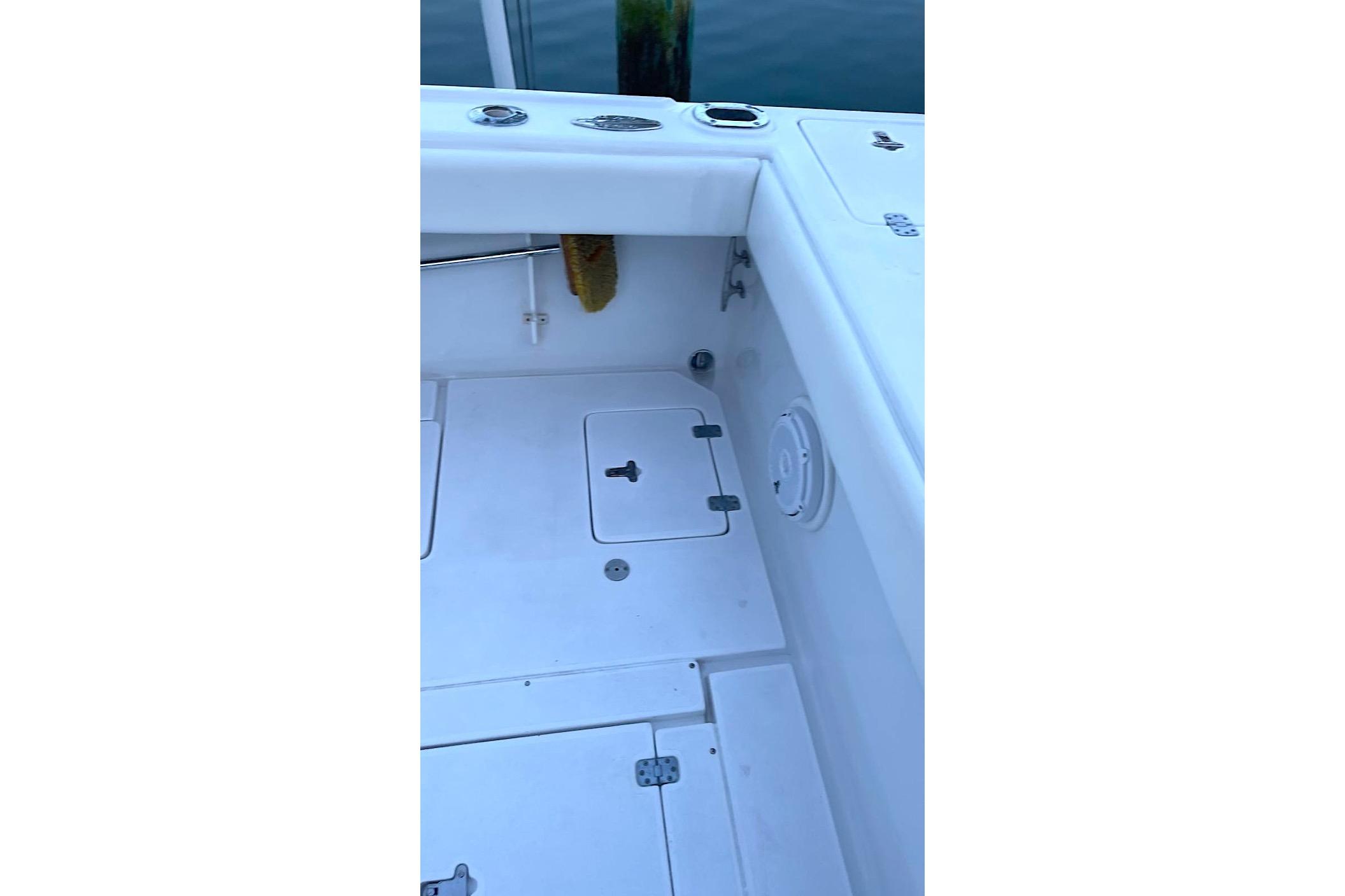 2002 Intrepid 323 Cuddy boat deck with storage compartments and clean white surface.