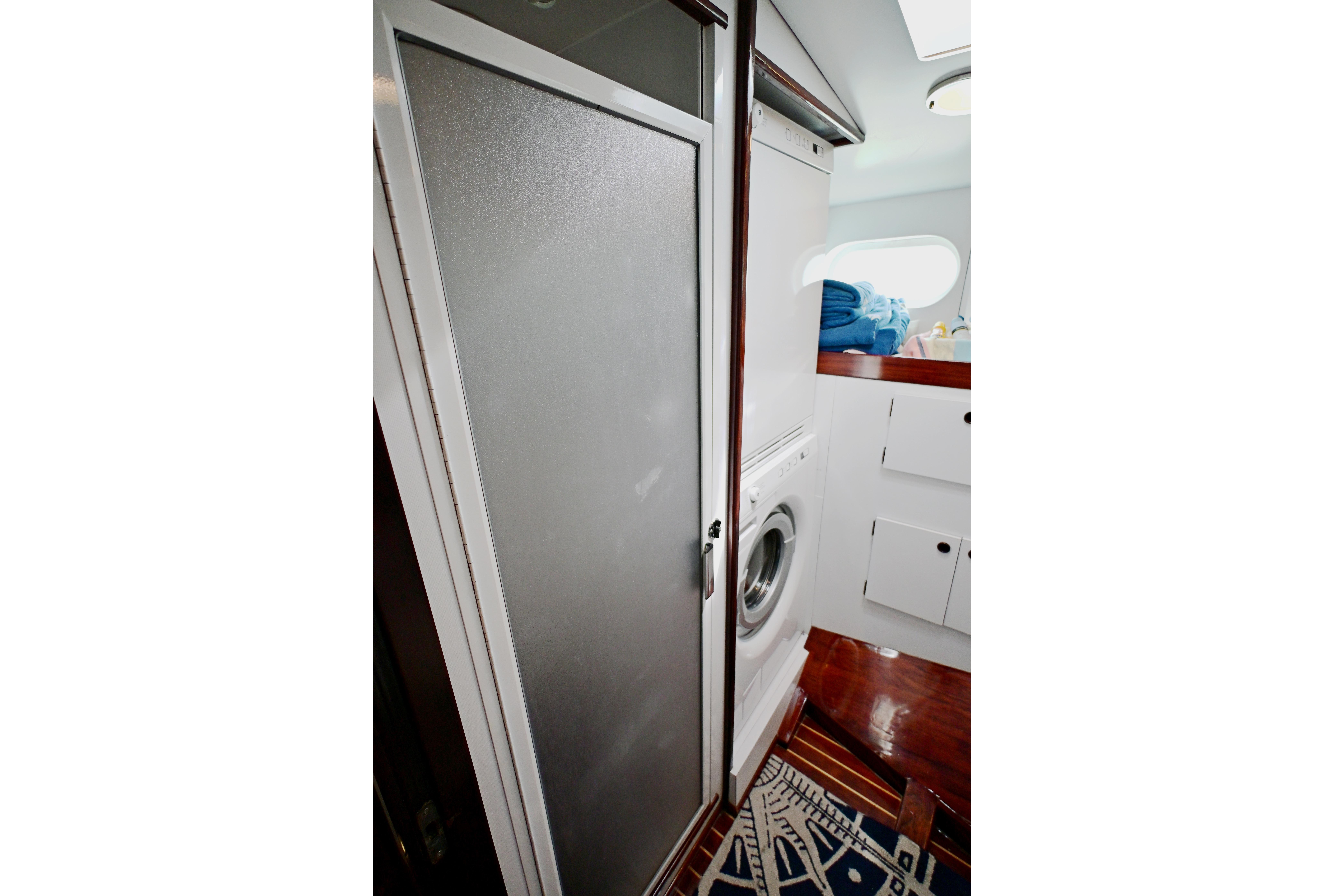 Laundry area on 1968 Abeking & Rasmussen Tripp 74 yacht with washing machine and storage.