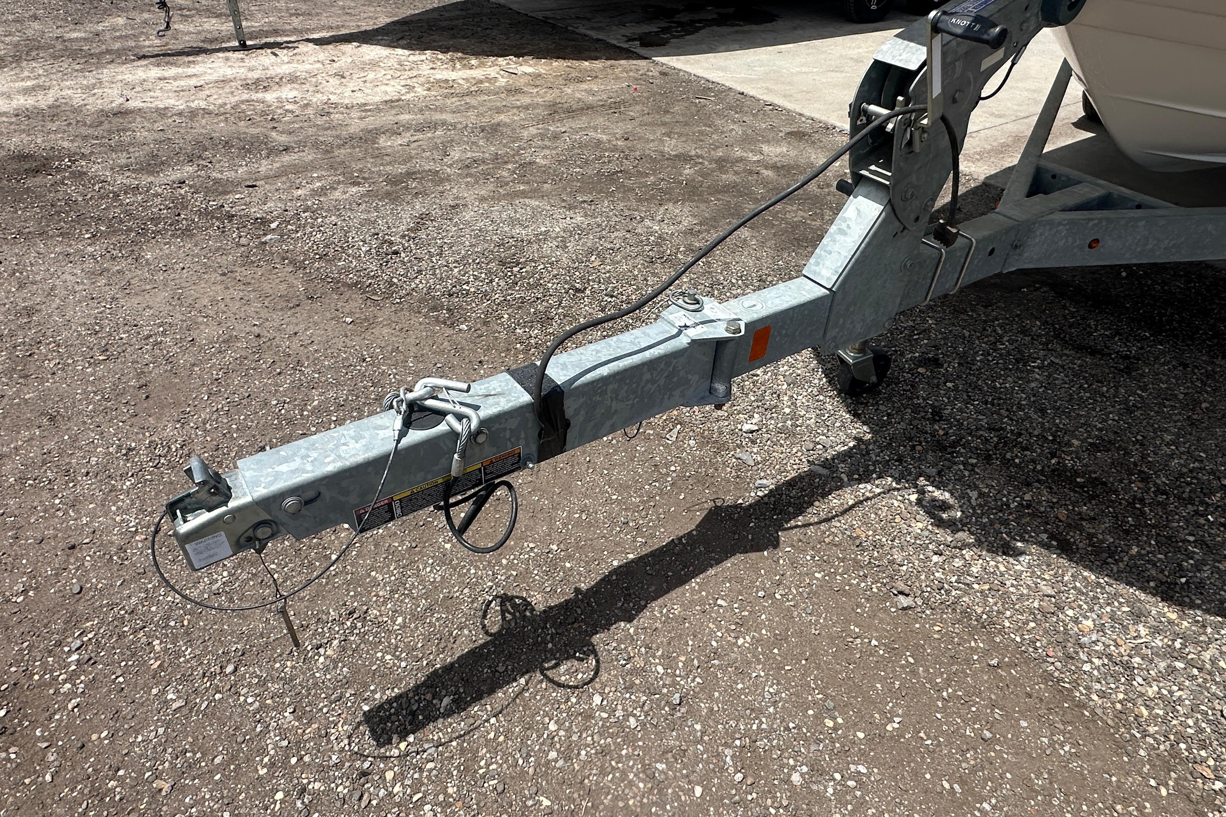 Trailer hitch of a 2017 Sea Ray SPX 190 Outboard on gravel surface.