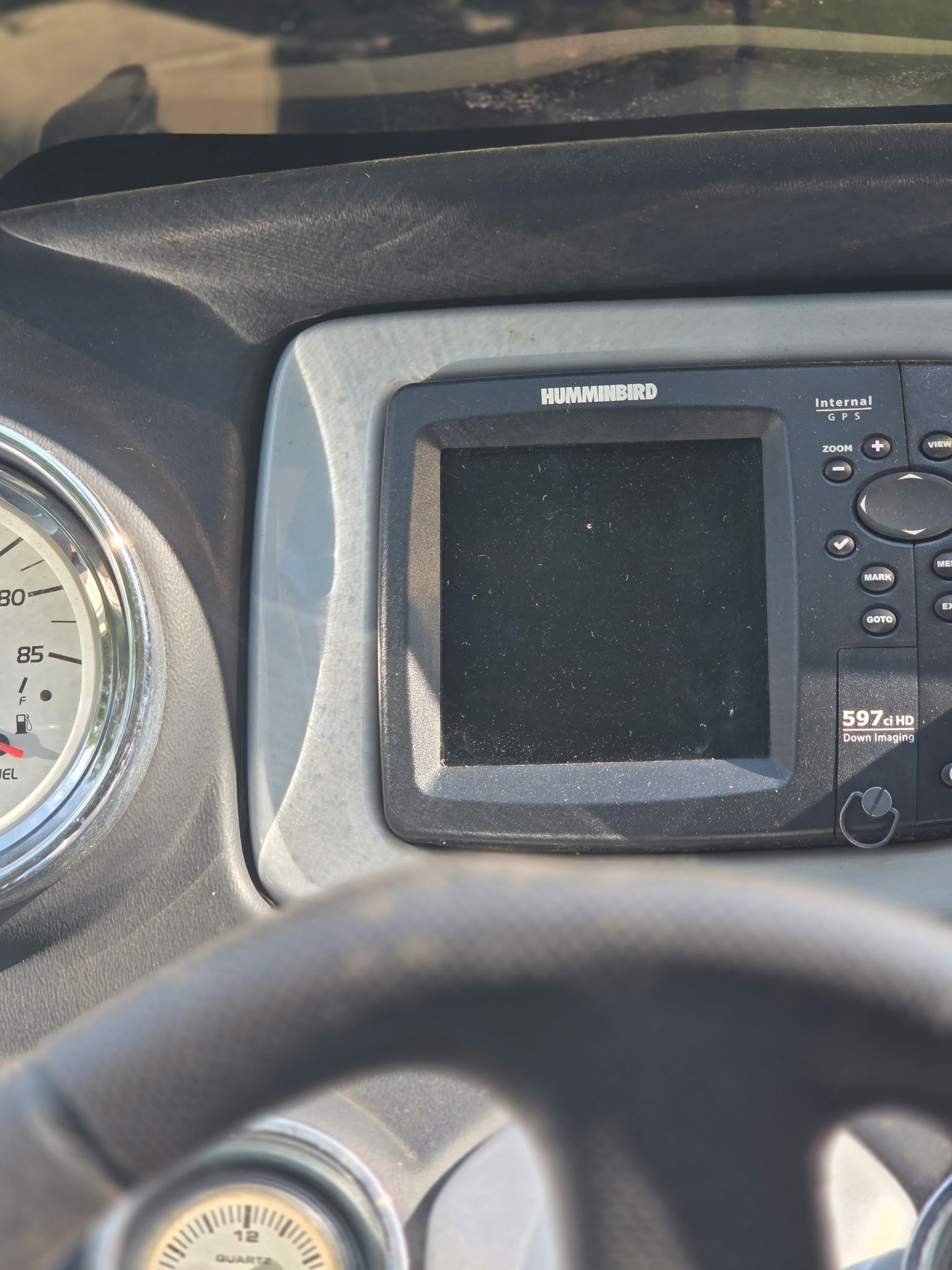 Close-up of a boat dashboard featuring a Humminbird fish finder and a speedometer.