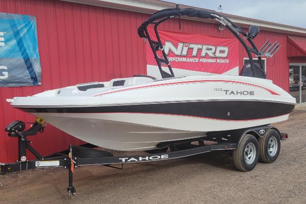 2024 Tahoe 1950 boat on trailer outside red building.