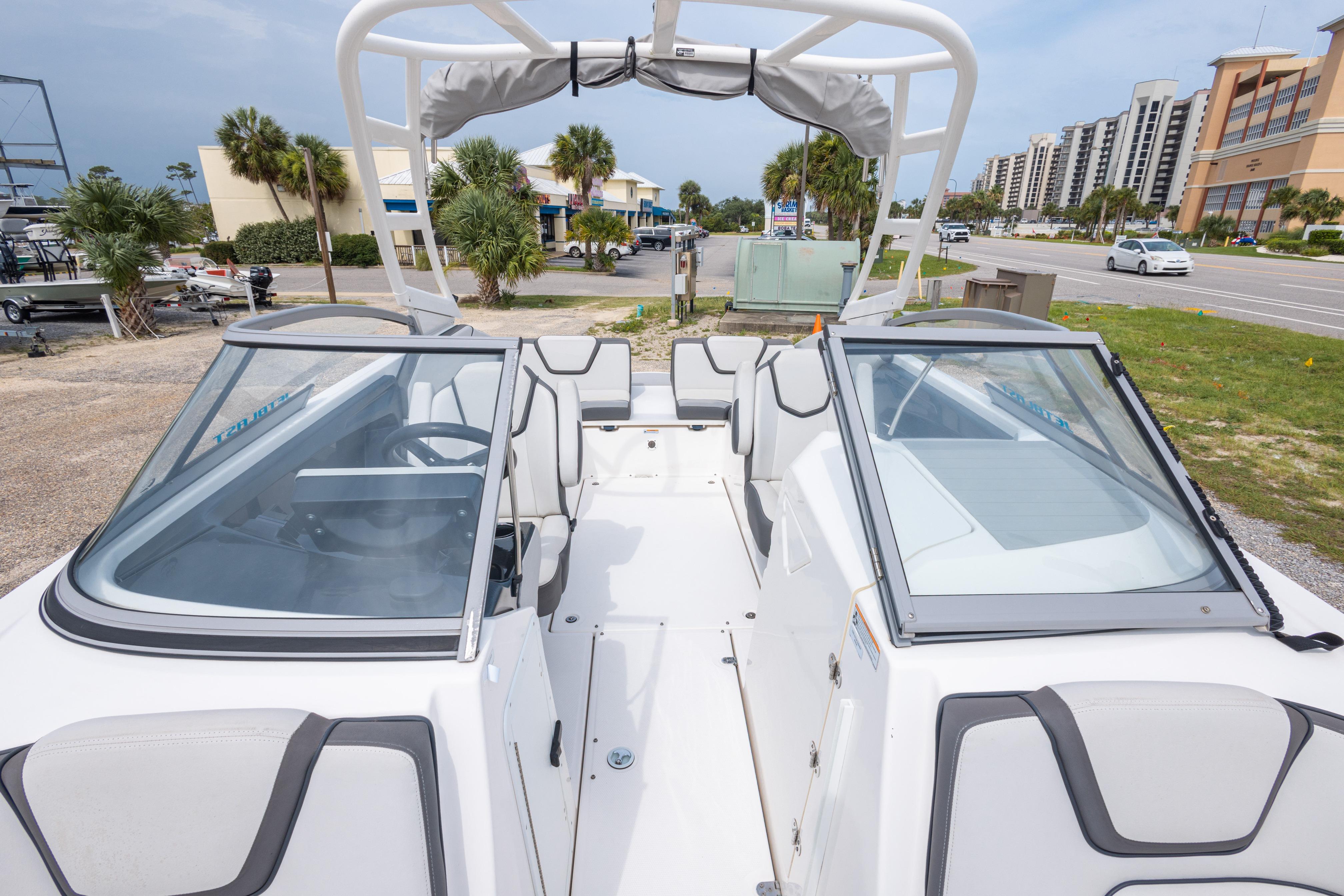2021 Yamaha Boats AR250 interior view with seating and windshield, parked near a road.