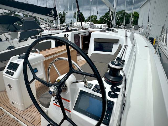 2024 Jeanneau Sun Odyssey 410 sailboat cockpit with steering wheel and navigation equipment.