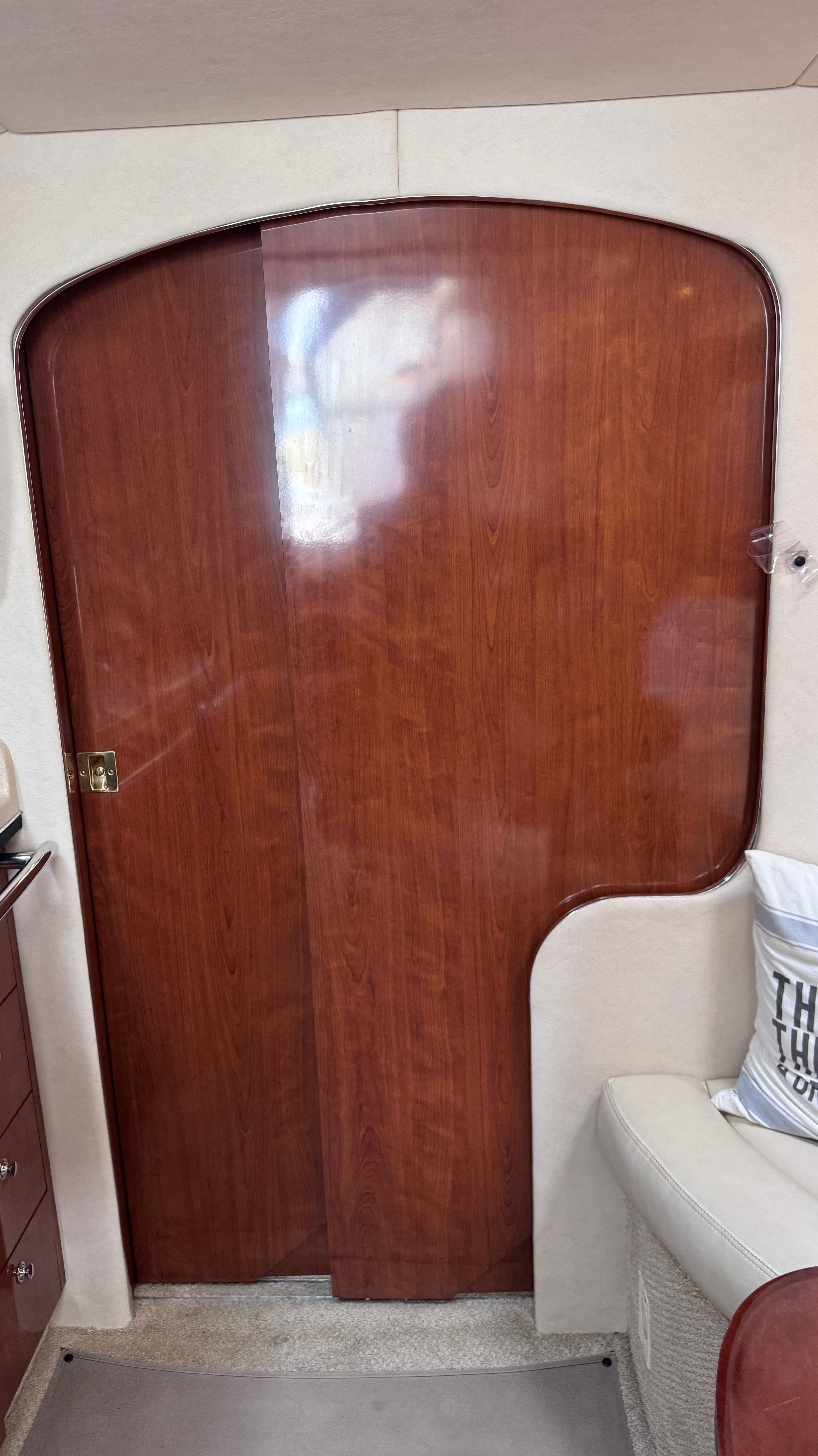 The cabin of the 2003 Sea Ray 360 Sundancer features a wooden door and a sofa.