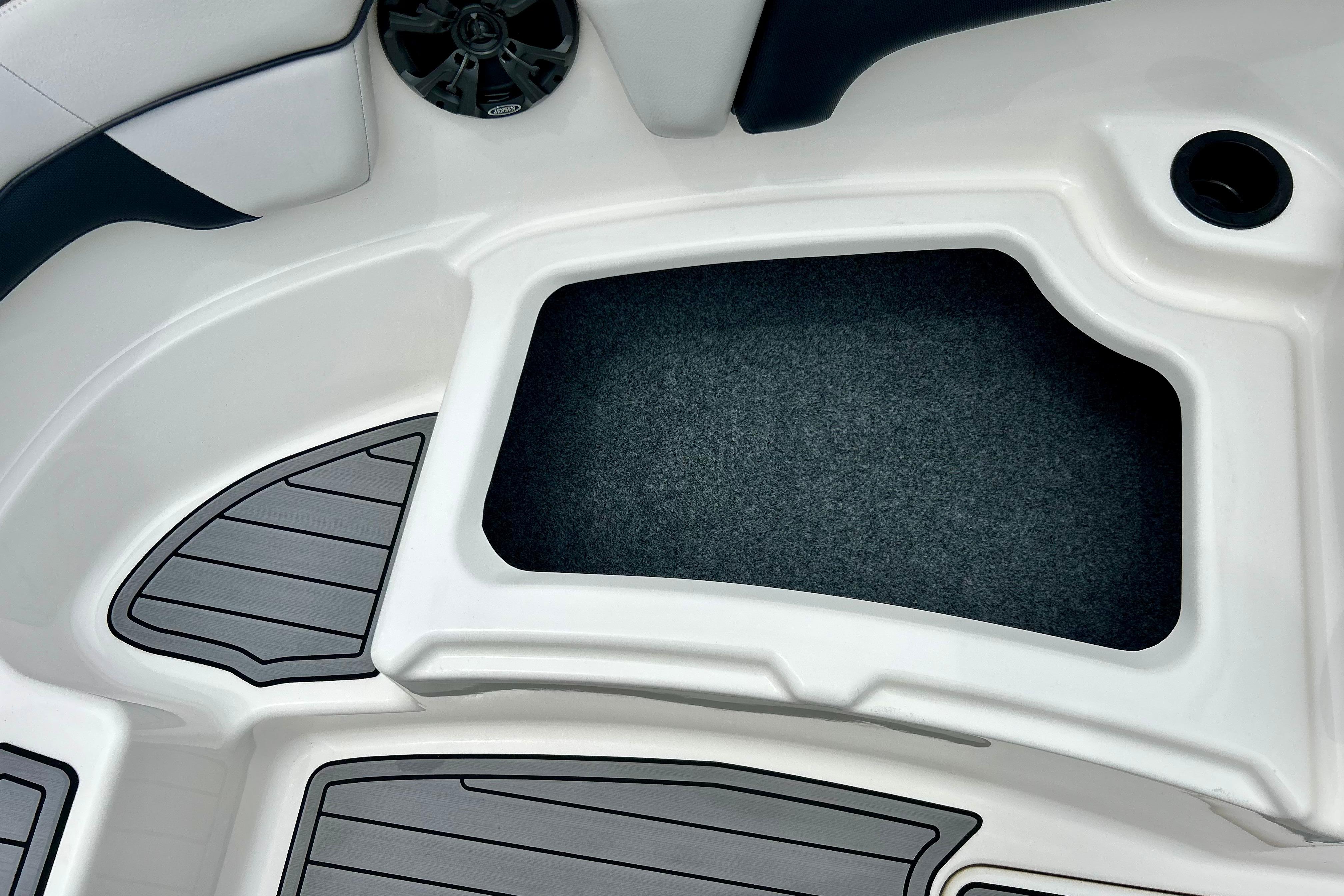 Interior view of a 2015 Yamaha AR210 boat, featuring storage compartment and speaker.