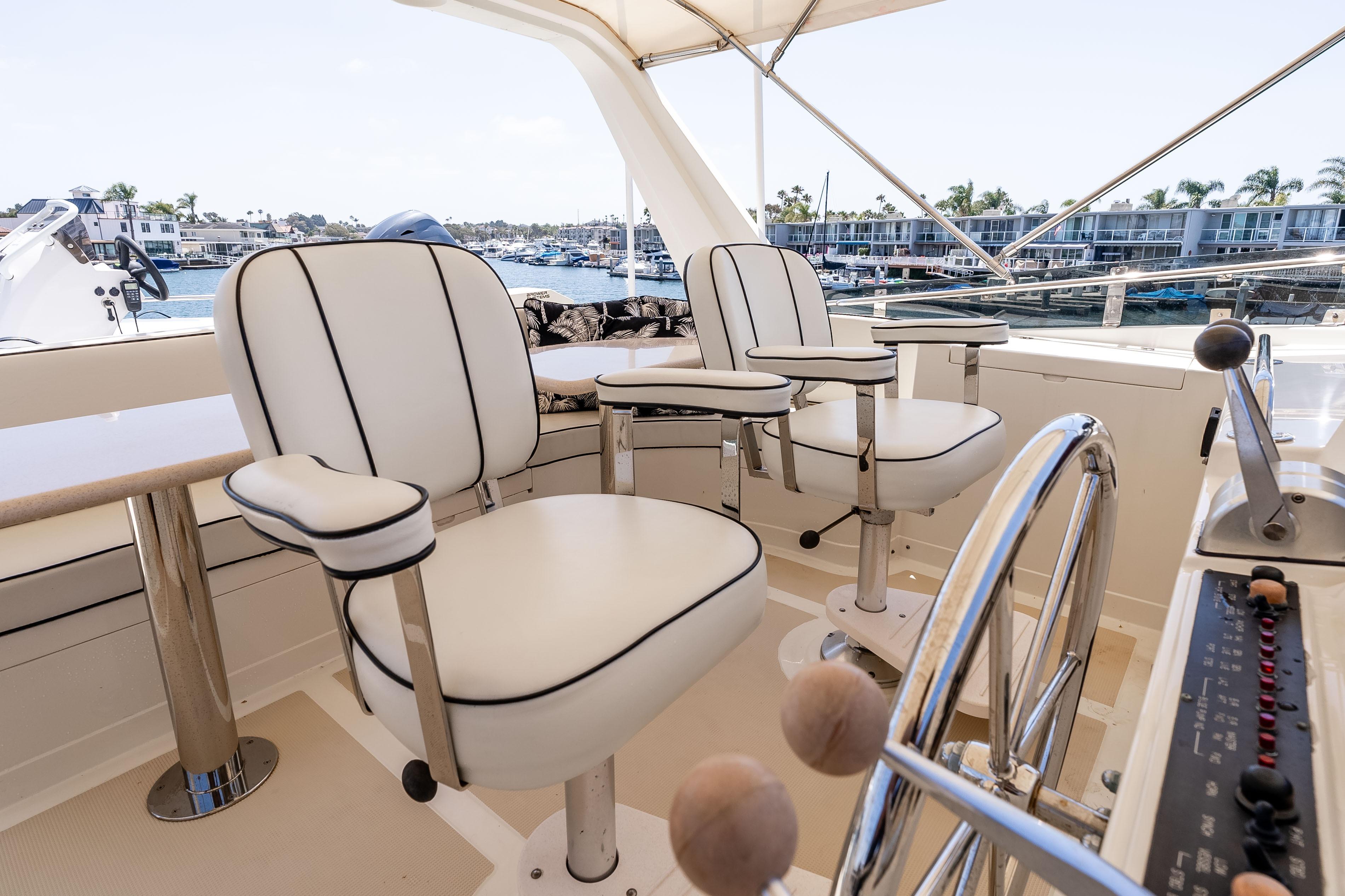 Pilothouse of 2005 Offshore Yachts 54, featuring elegant seating and steering wheel.
