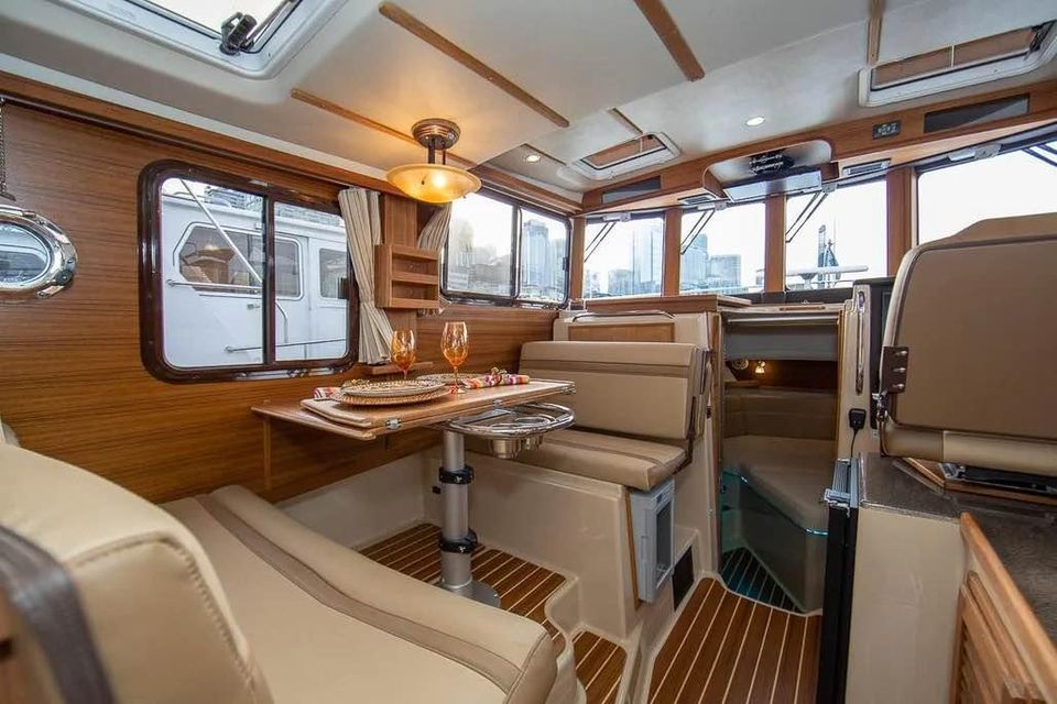 Interior of the 2023 Ranger Tugs R 31 LE with elegant wood finish and cozy seating.