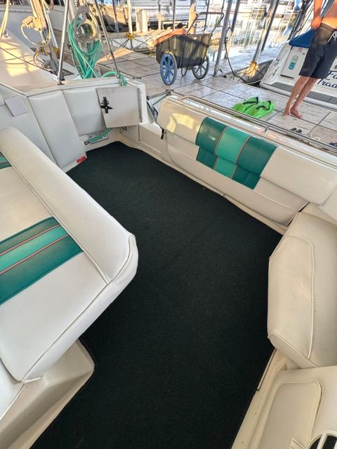 Interior of a 1992 Sea Ray 290 Sundancer with white and green seating.
