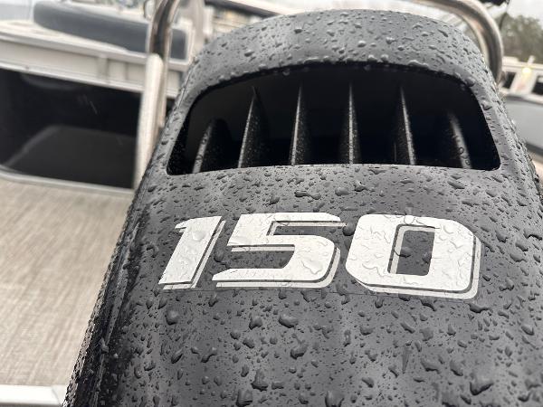 Close-up of a wet 150 horsepower engine on a 2025 Avalon LSZ Quad Lounger boat.