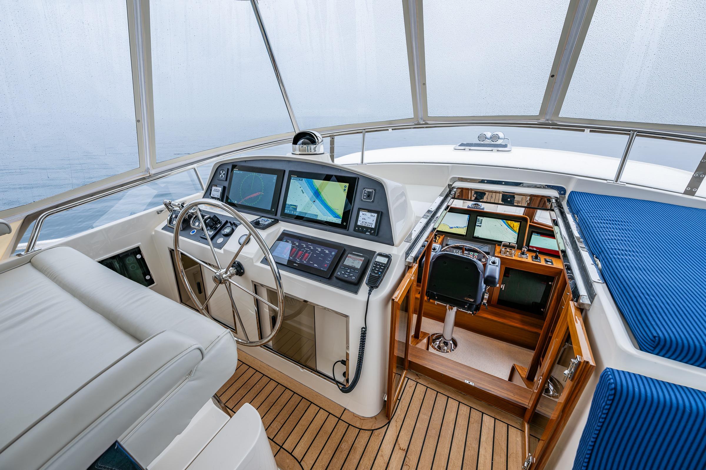 Pilothouse interior of 2026 Fleming 55 yacht, featuring modern navigation equipment and luxurious seating.
