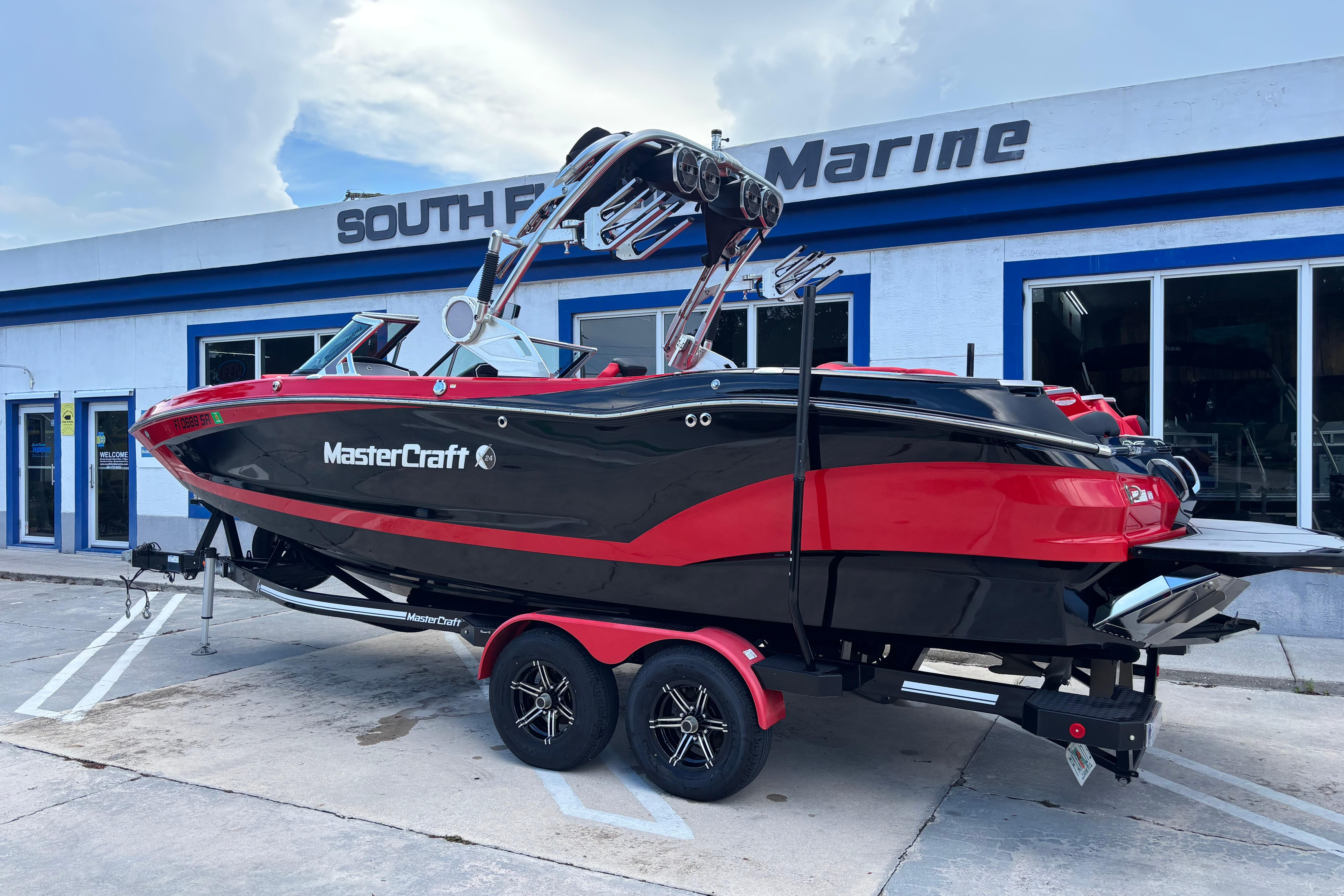 2020 MasterCraft X24 boat in red and black, parked at South Florida Marine.