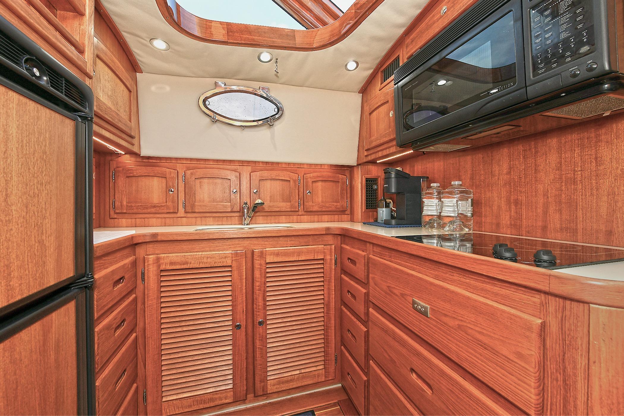 Luxurious wooden interior of 2005 San Juan Downeast Express yacht kitchen.