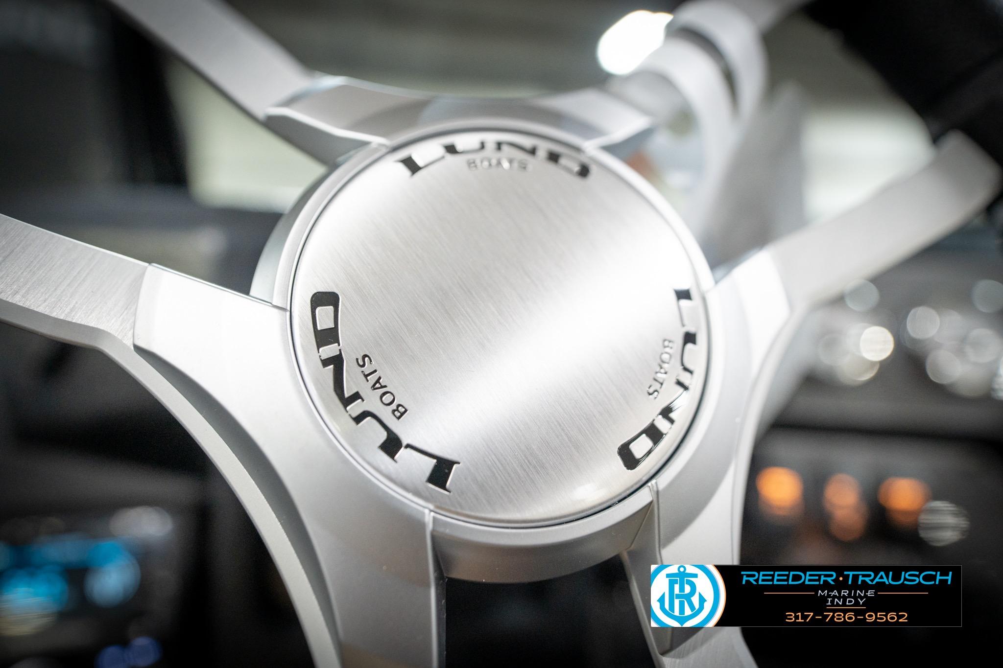 Steering wheel of 2026 Lund 2275 Baron boat, featuring sleek metallic design.