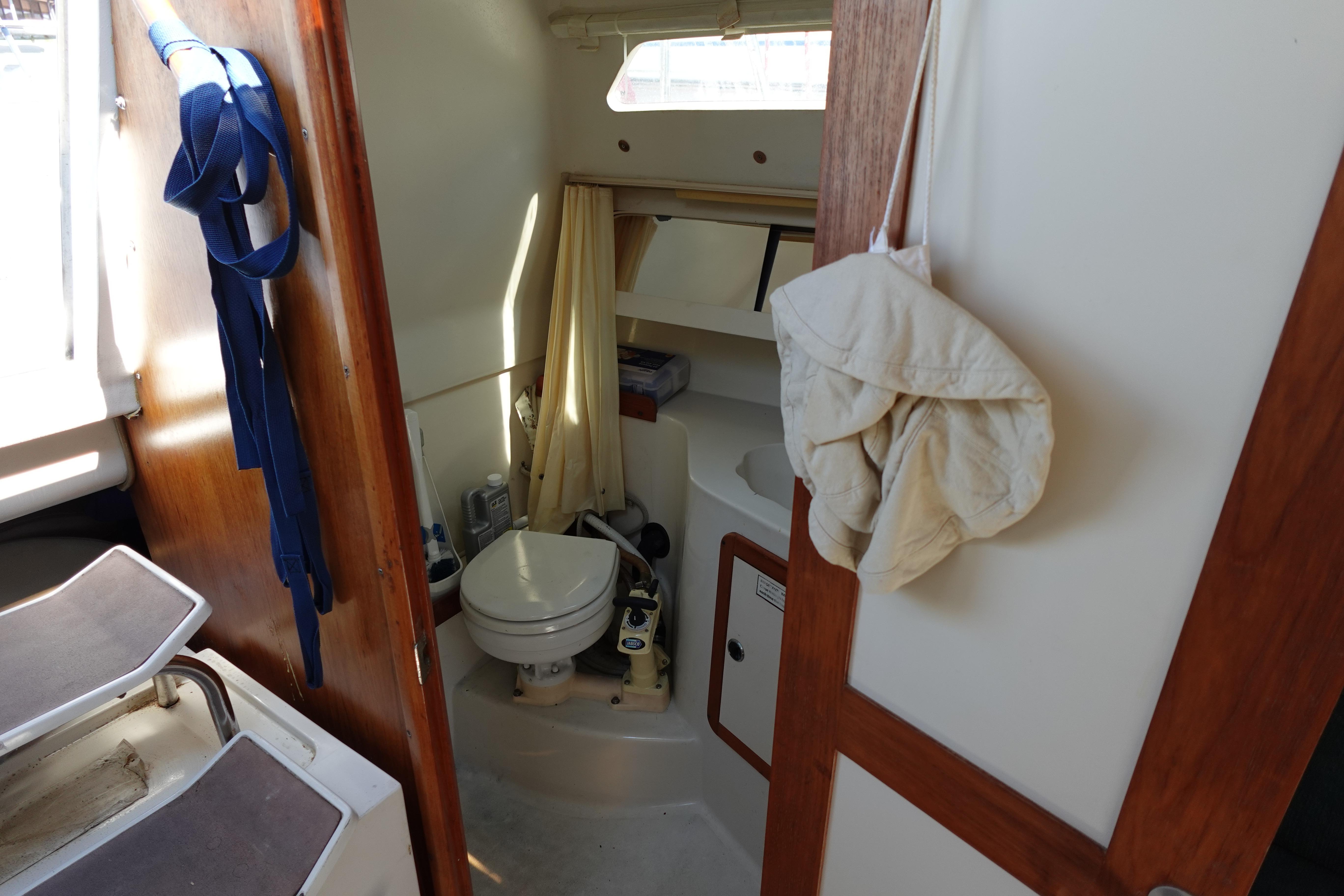 Interior of 1997 Catalina 28 sailboat bathroom with toilet and wooden accents.