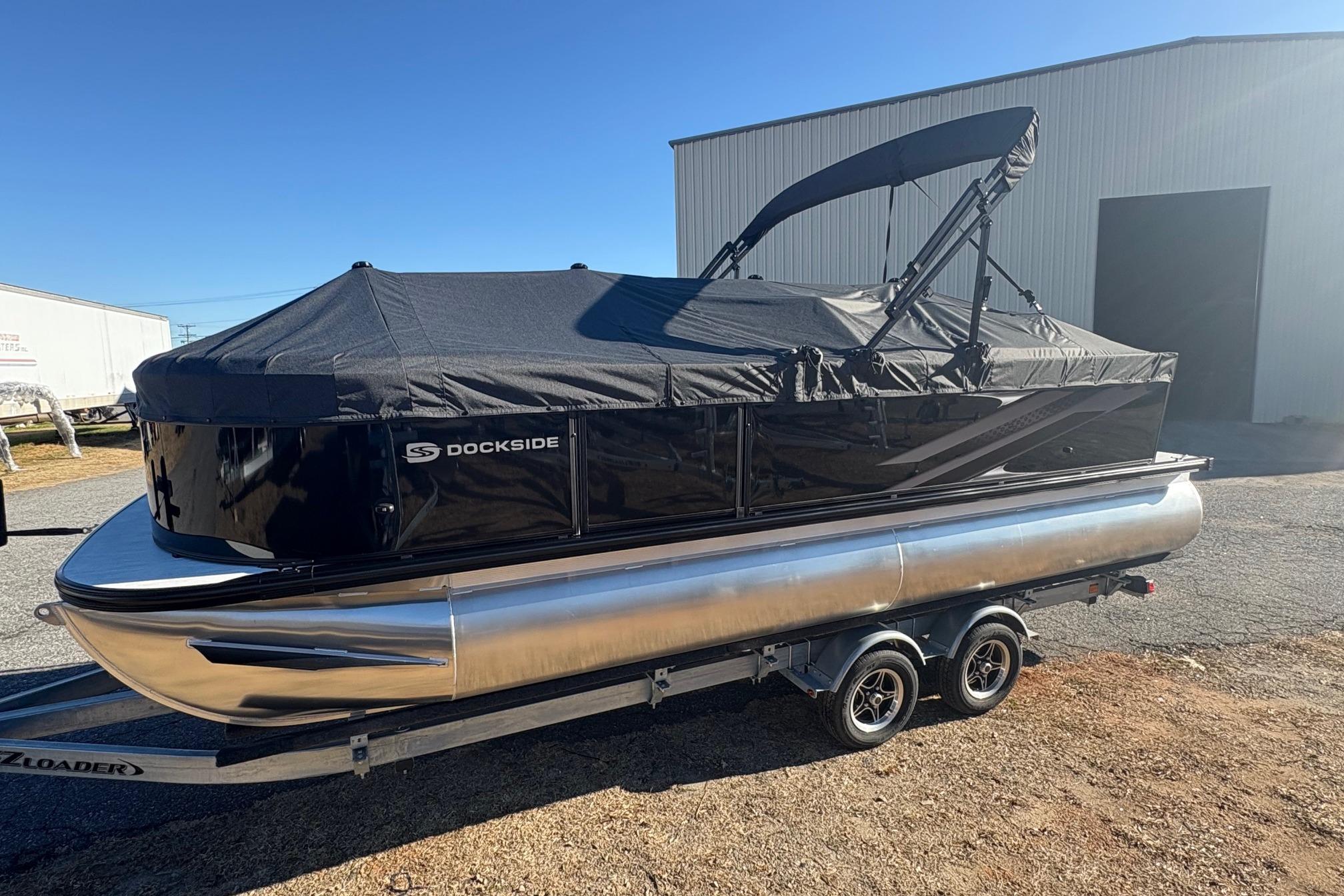 2026 Dockside 22DQ pontoon boat with black cover on trailer, parked outdoors.