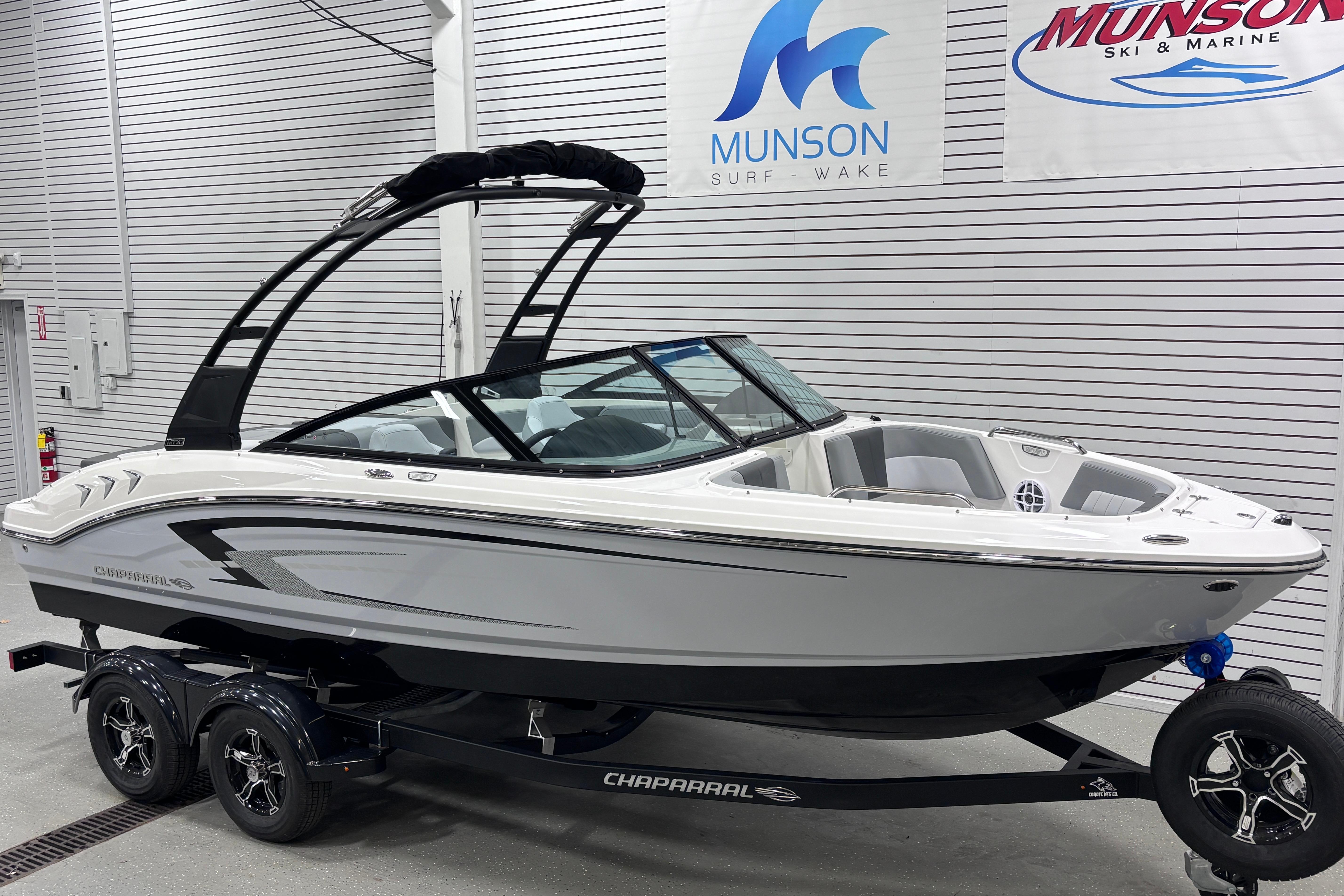 2026 Chaparral 21 SSi boat on trailer in showroom, Munson Surf Wake banners.