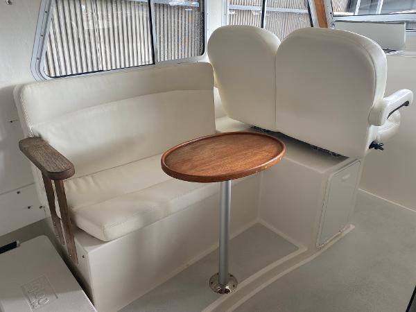 Interior of a 2015 Eastern 27 Islander with white seating and a round wooden table.