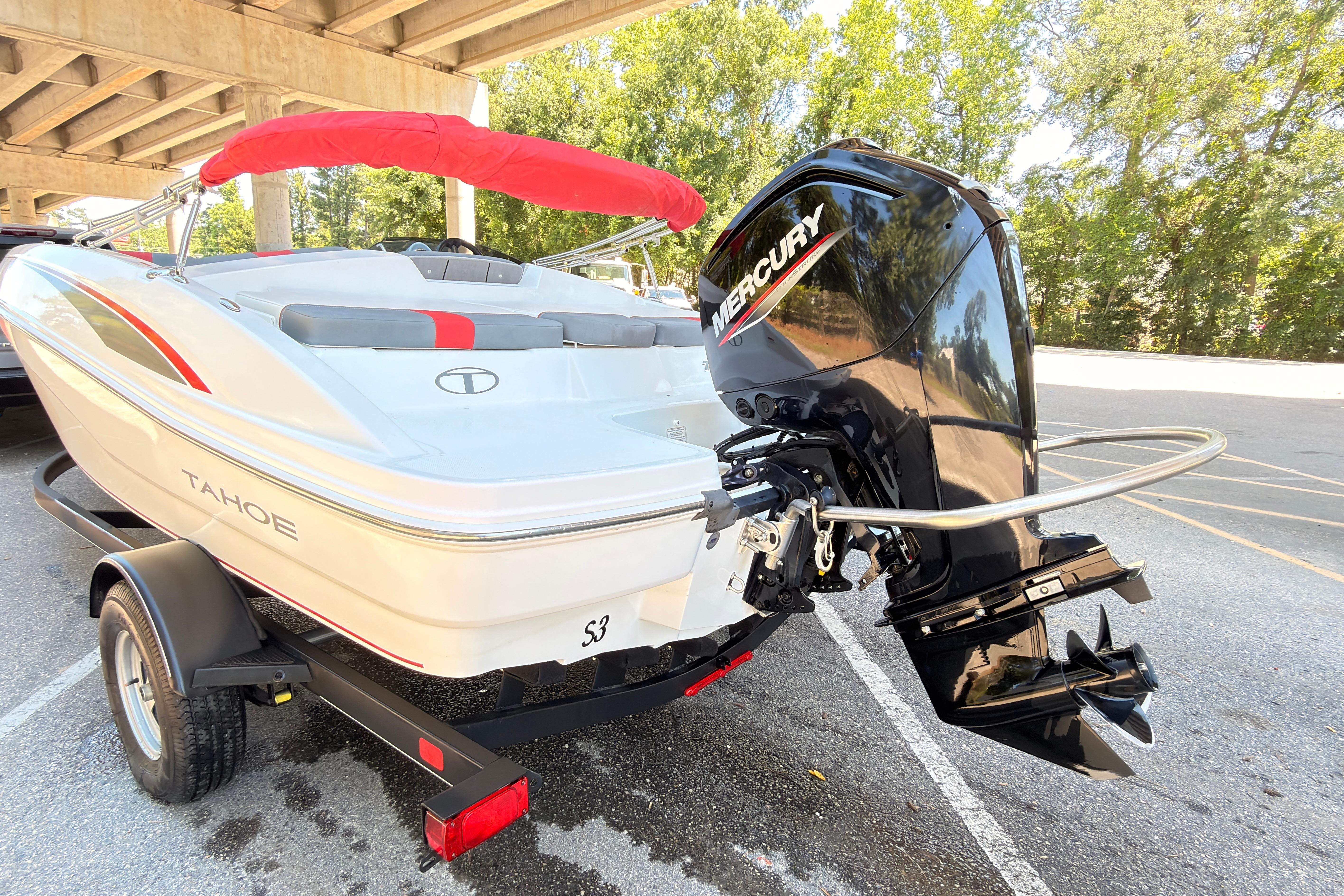 2022 Tahoe T18 boat with Mercury outboard motor on trailer, parked under bridge.