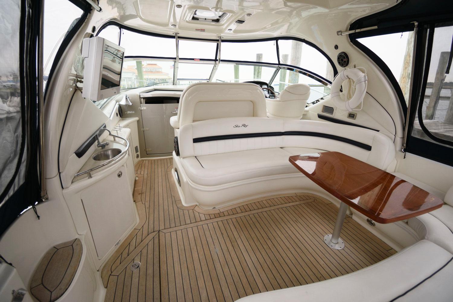 Interior of 2008 Sea Ray 44 Sundancer yacht with white seating and wooden table.
