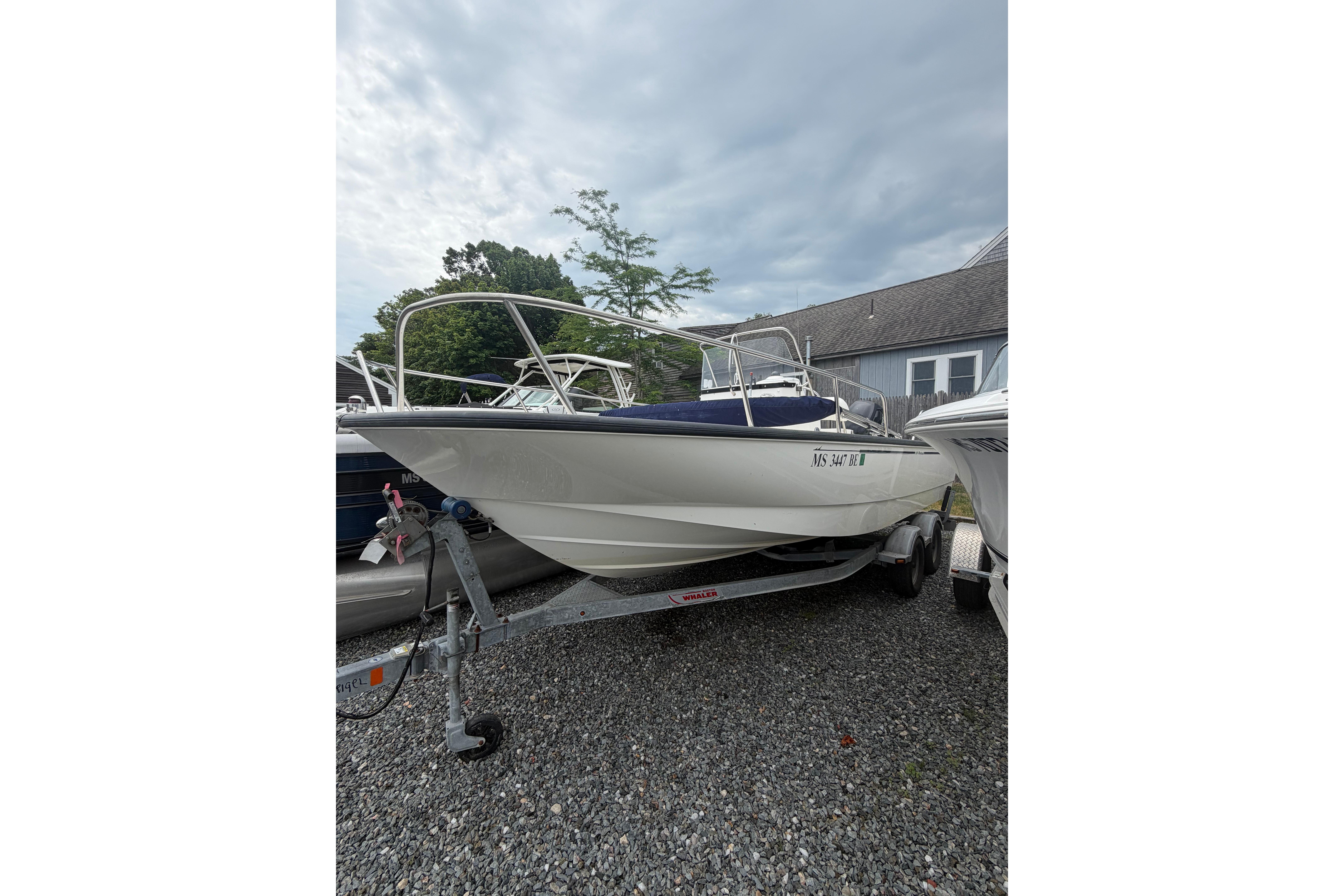 2015 Boston Whaler 210 Montauk boat on trailer, parked outdoors.