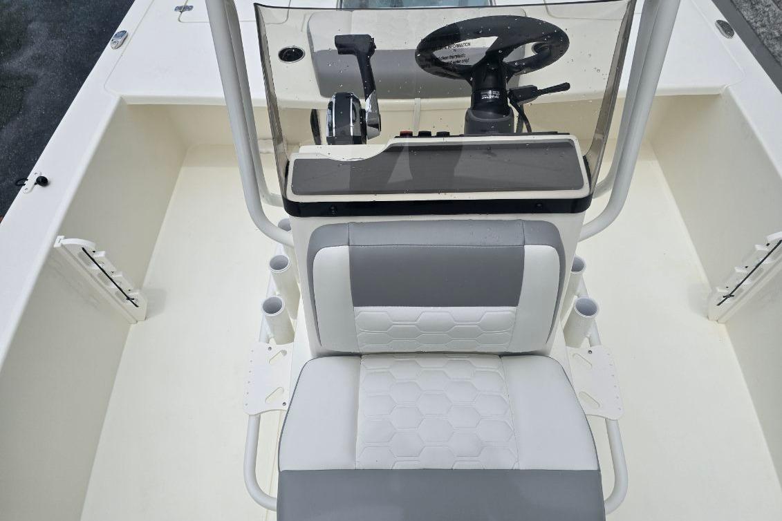 2026 Mako 18 Pro Skiff boat interior with steering console and cushioned seating.