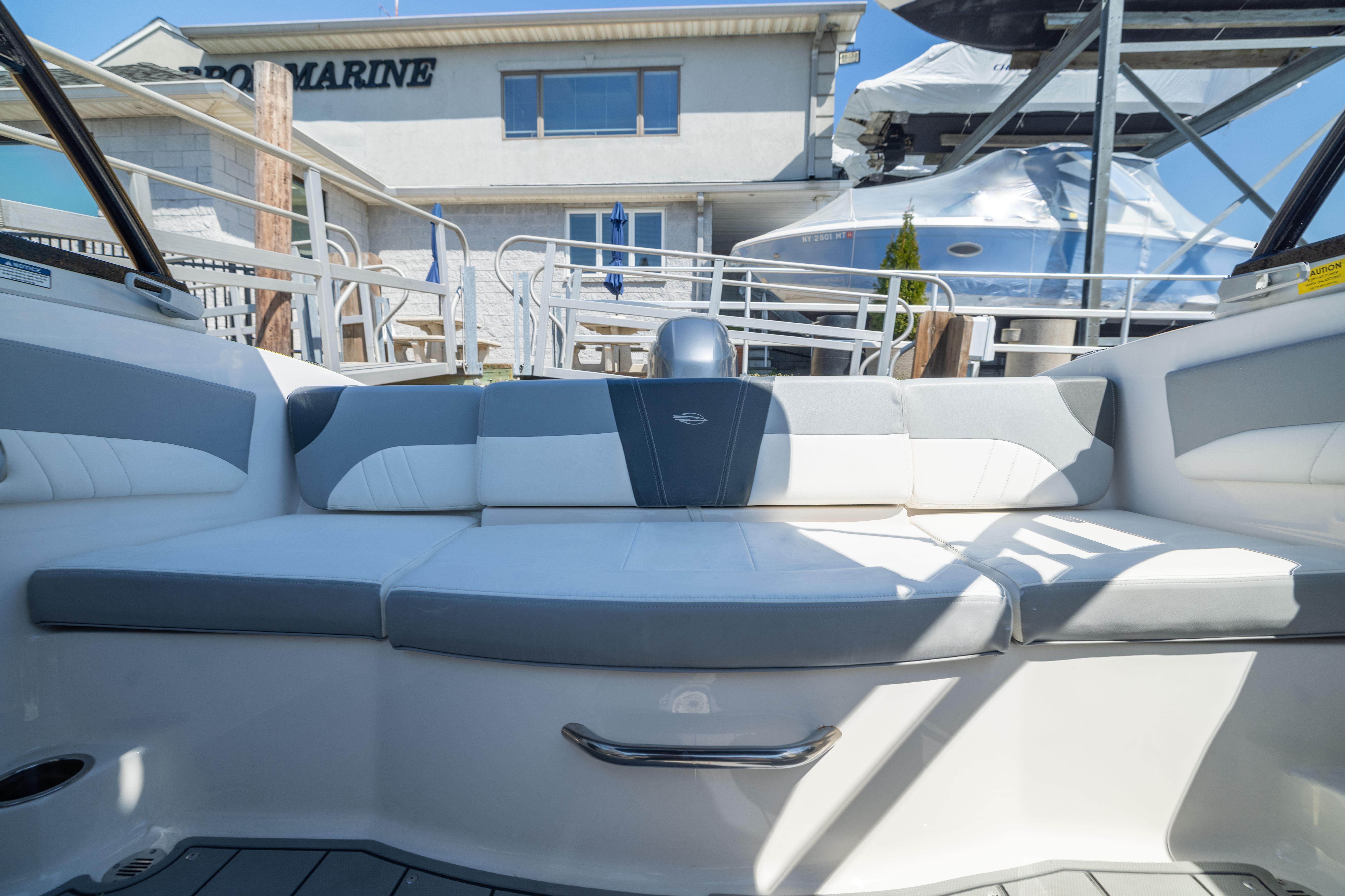 2022 Chaparral 21 SSi OB boat interior with comfortable seating at a marina.