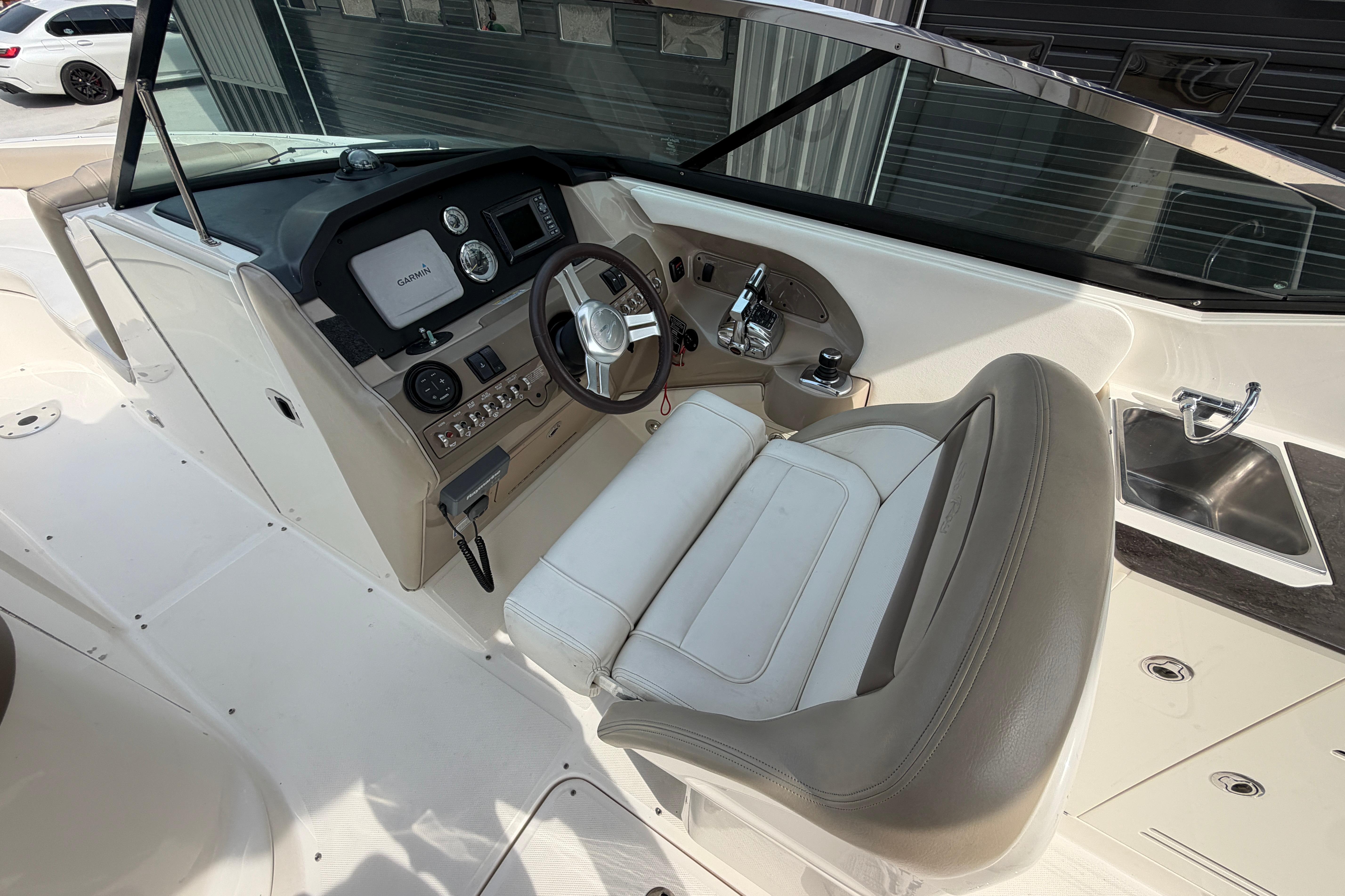 2013 Sea Ray 300 SLX boat cockpit with steering wheel, Garmin display, and sink.