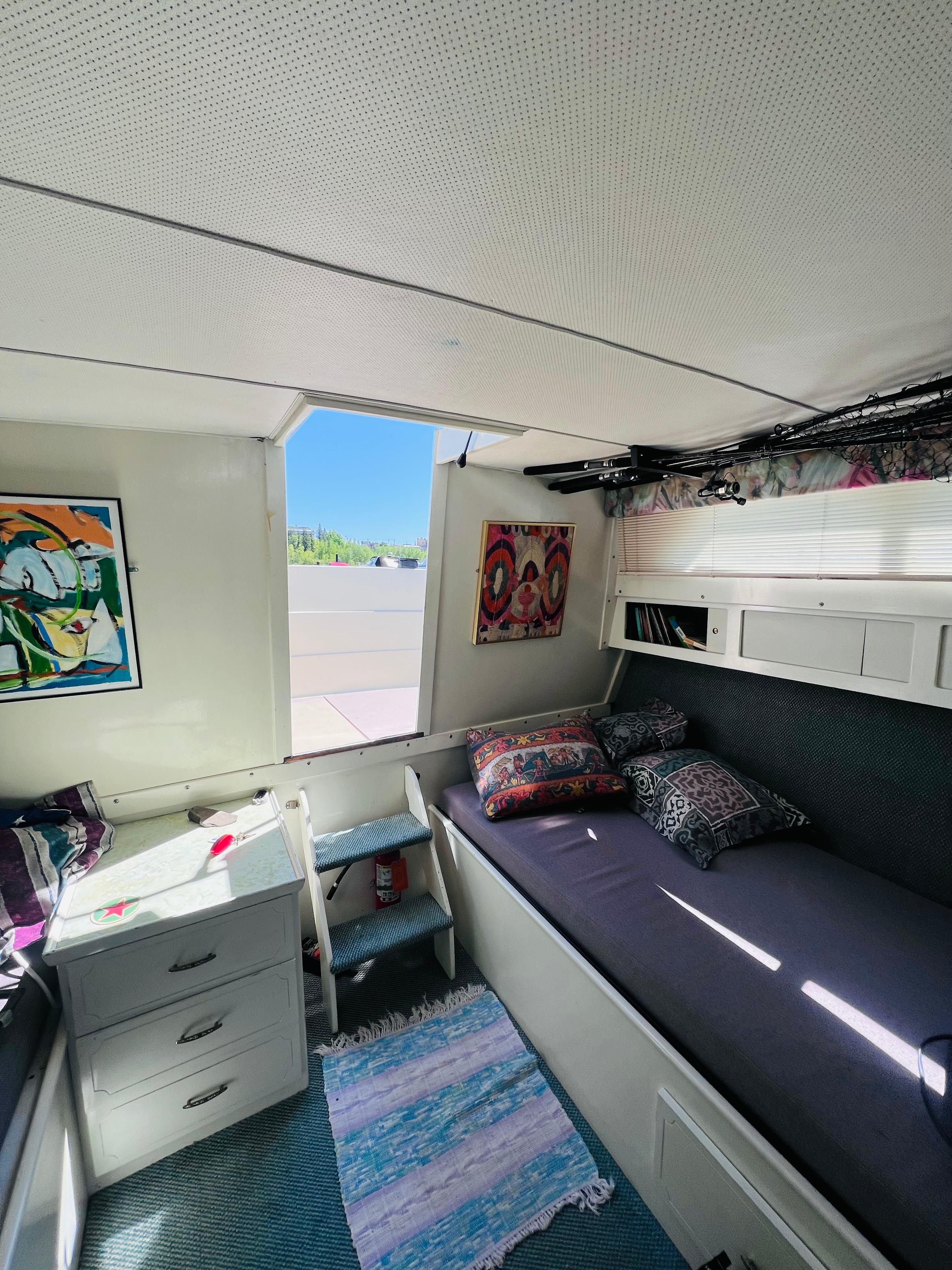 1974 Tollycraft 40 Tri-Cabin Motoryacht interior with bed, colorful pillows, and wall art.