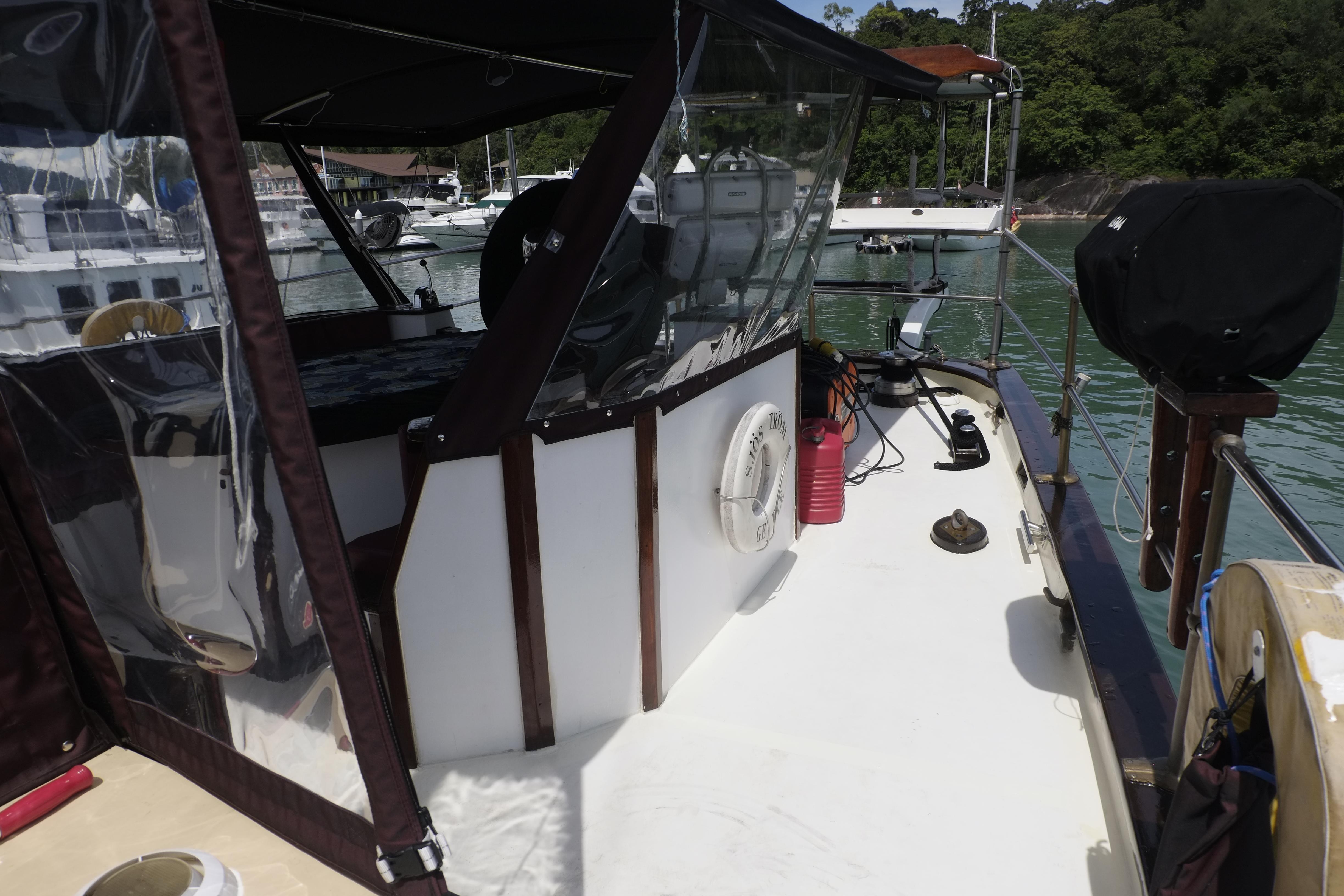 Custom Bud Macintosh schooner deck, 2006 model, featuring covered seating and nautical equipment.