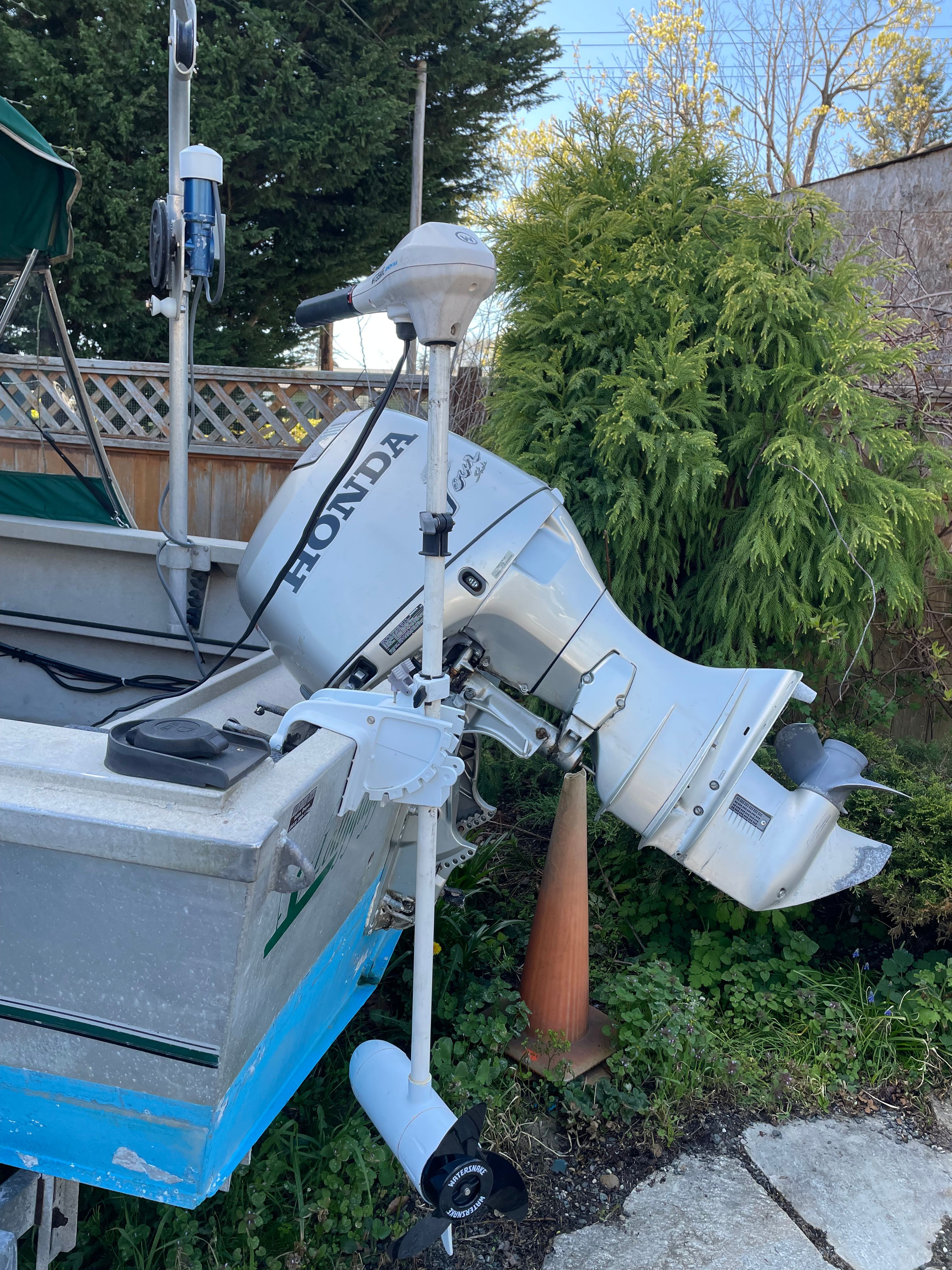A 2001 Alumaweld Stryker boat with a Honda outboard motor, positioned on land.
