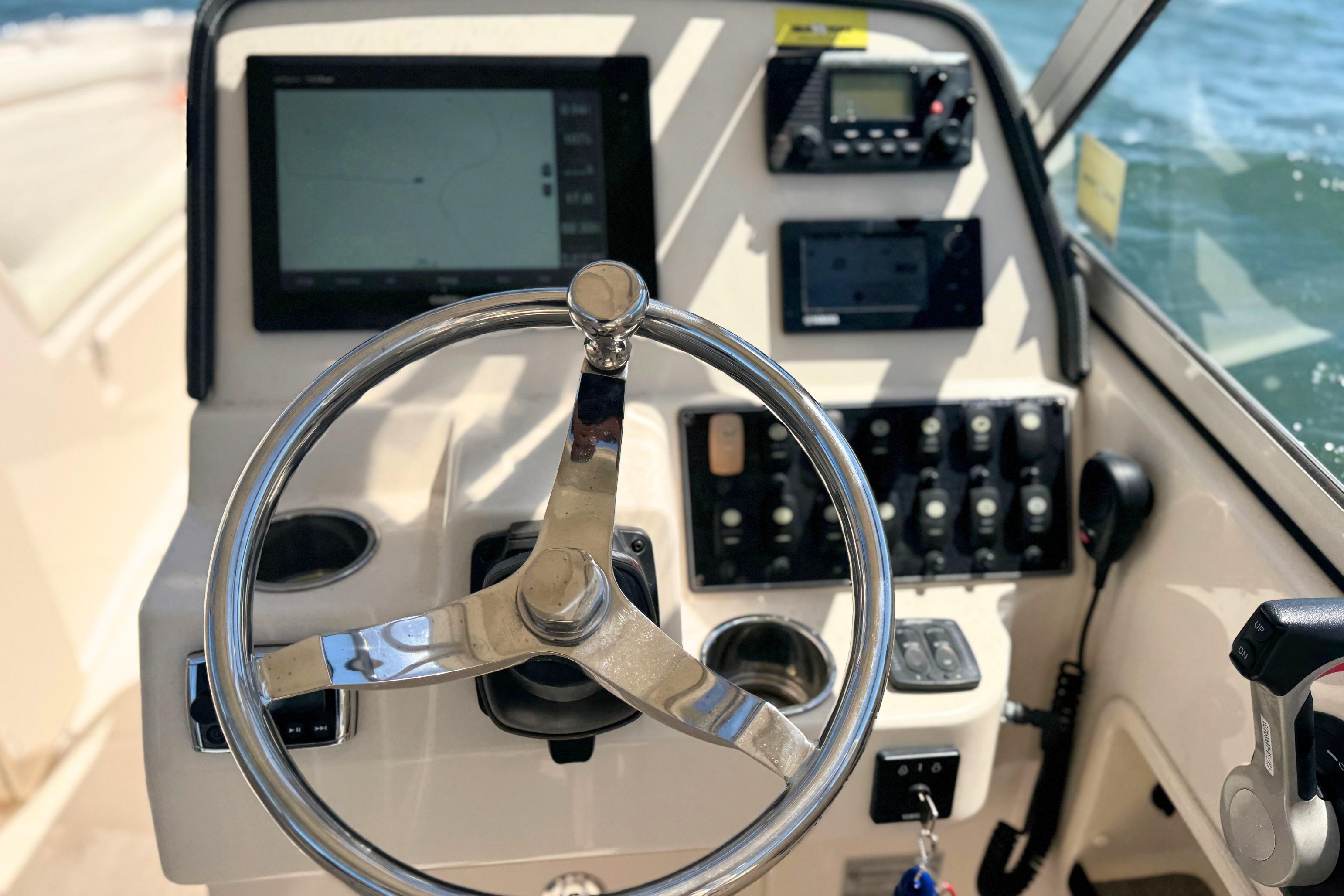Steering console of 2017 Grady-White Freedom 235 boat with navigation equipment.