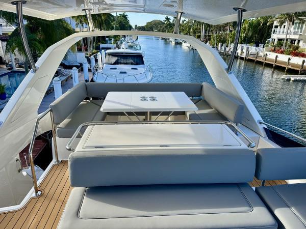Aquila 44 yacht deck with seating and table, docked in a scenic canal, 2022 model.