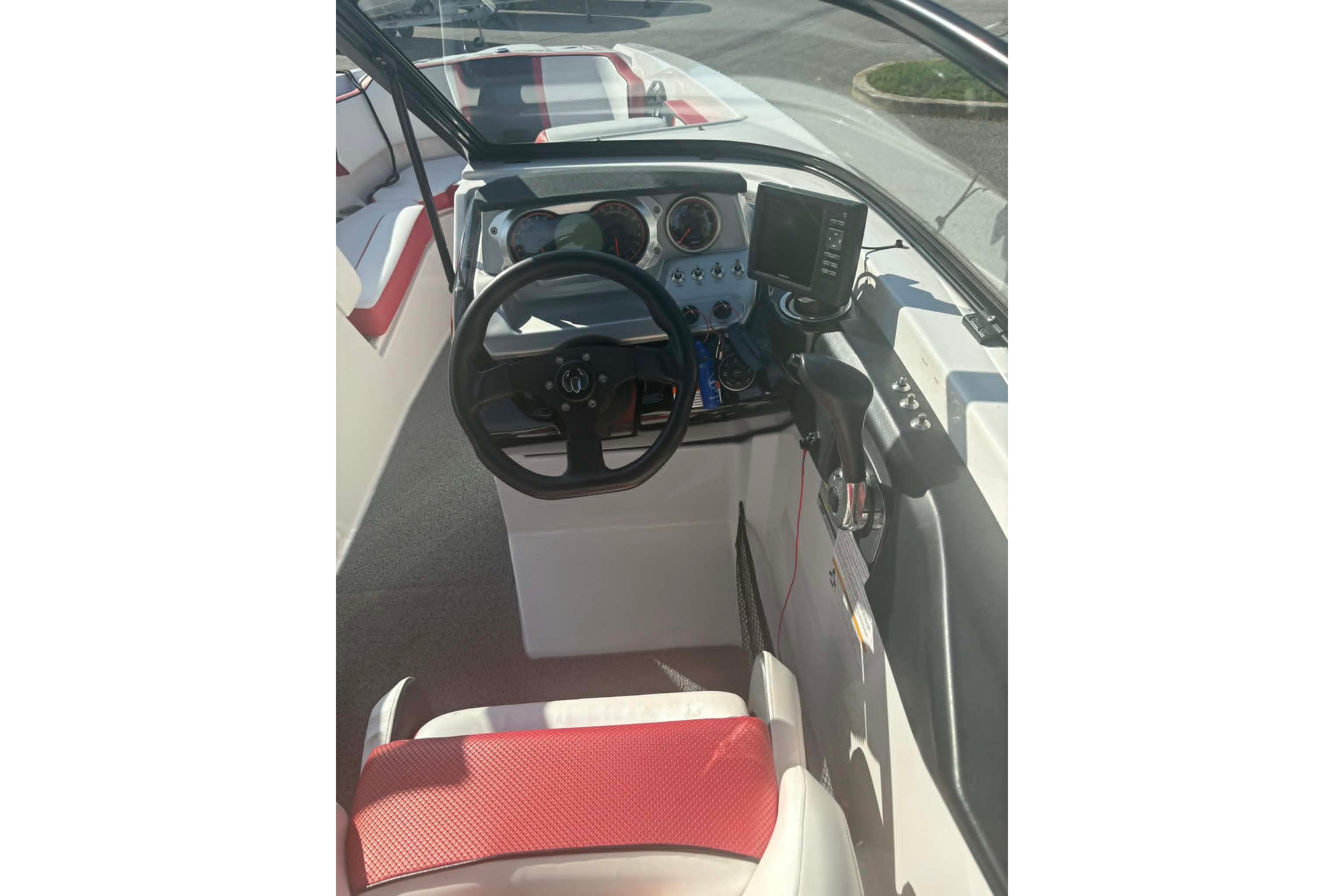 Interior view of 2016 Scarab 255 H.O. Impulse boat cockpit with steering wheel and controls.