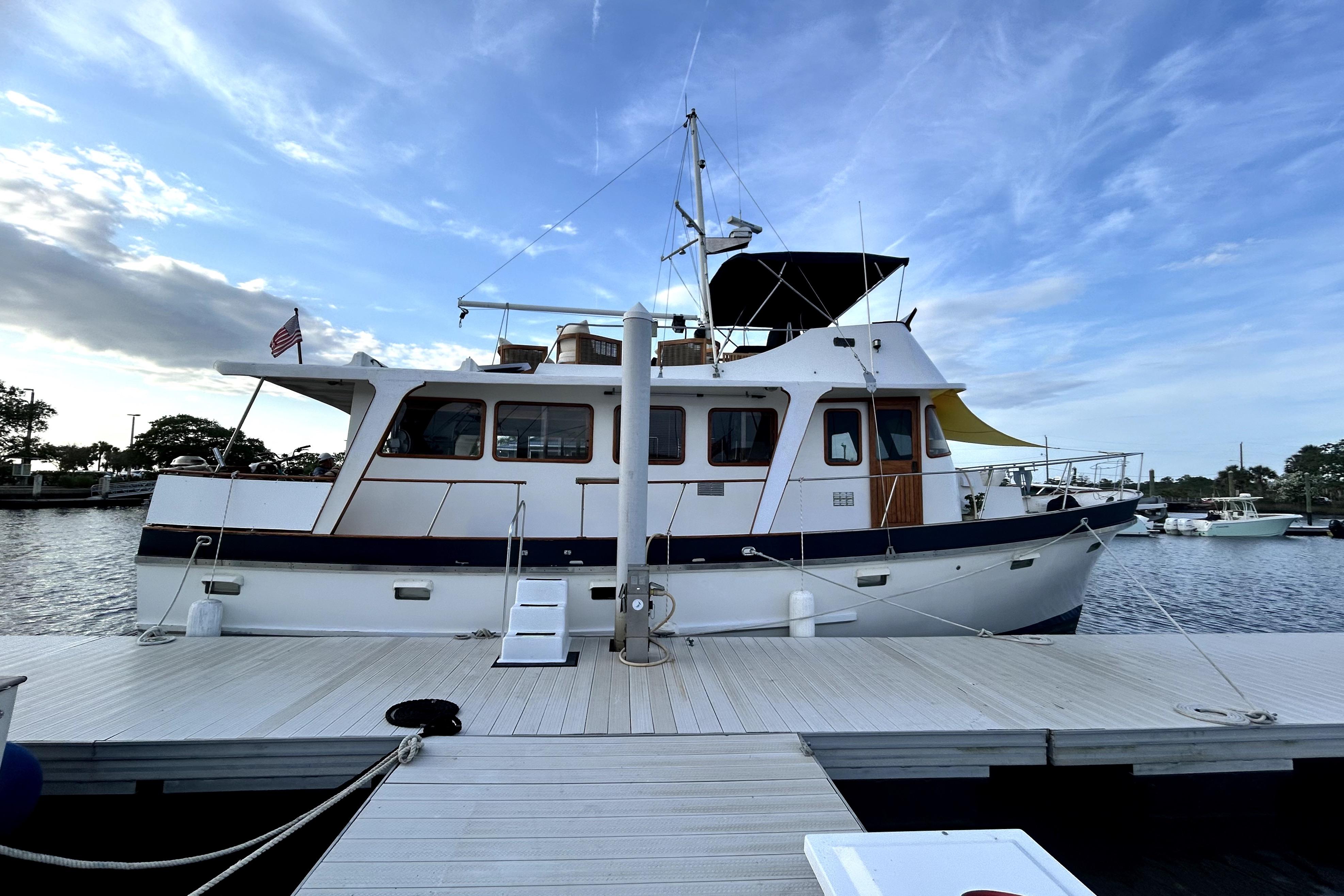 1979 Cheoy Lee 46 LRC yacht docked at marina under blue sky.