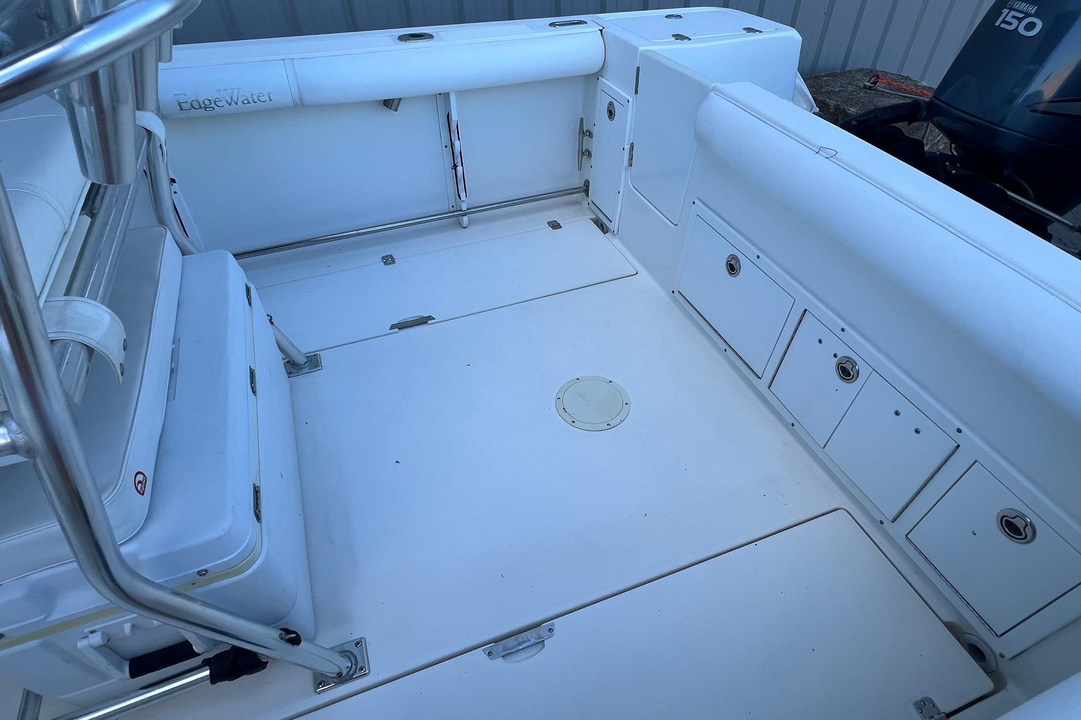 2006 Edgewater 245CC boat interior with white seating and storage compartments.