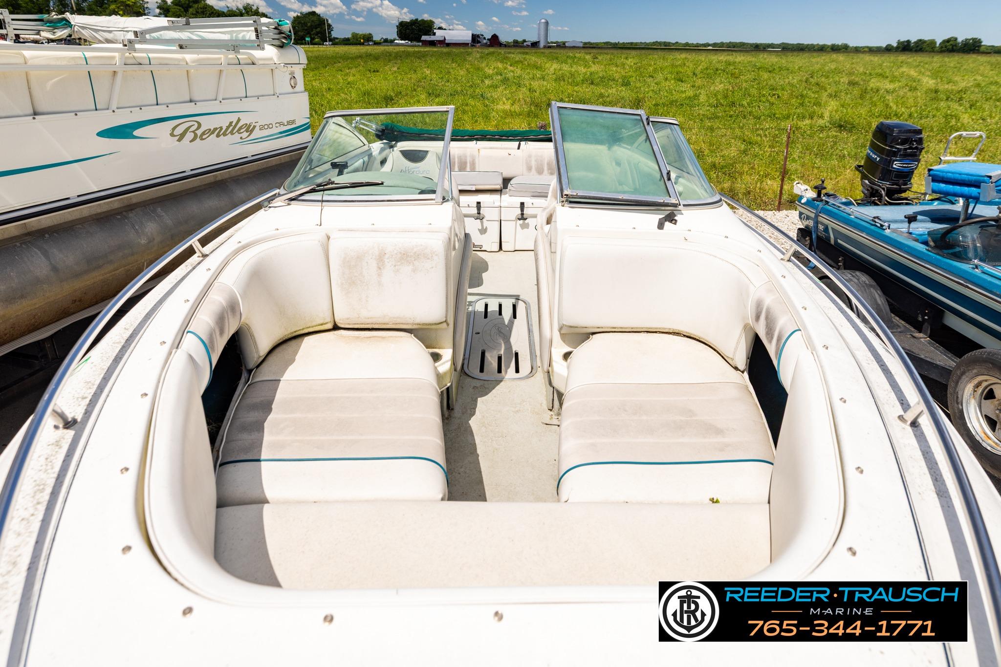 1996 Sea Ray 210 Bow Rider boat with spacious seating, parked outdoors.