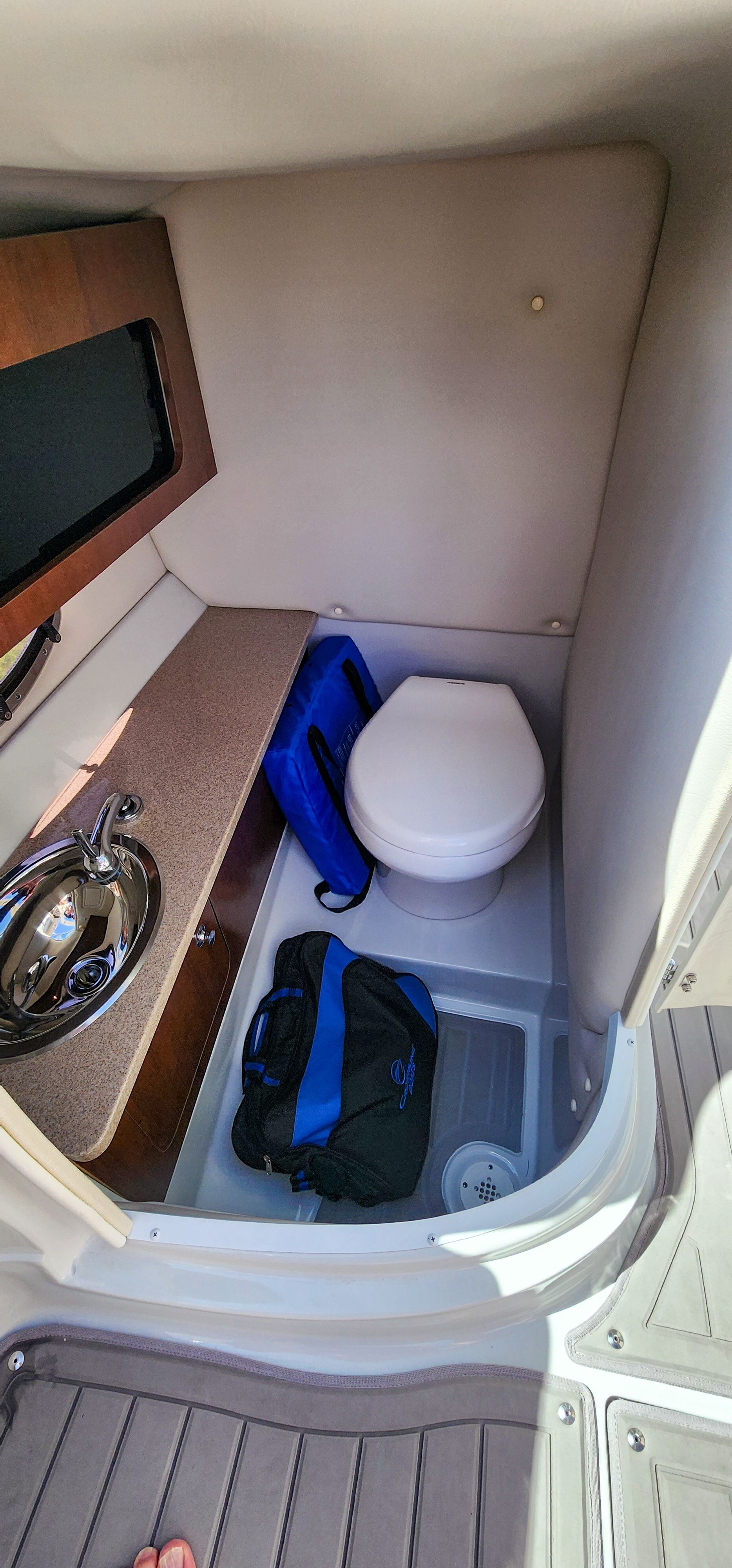 Interior of a 2017 Crownline 285SS featuring a toilet and sink.